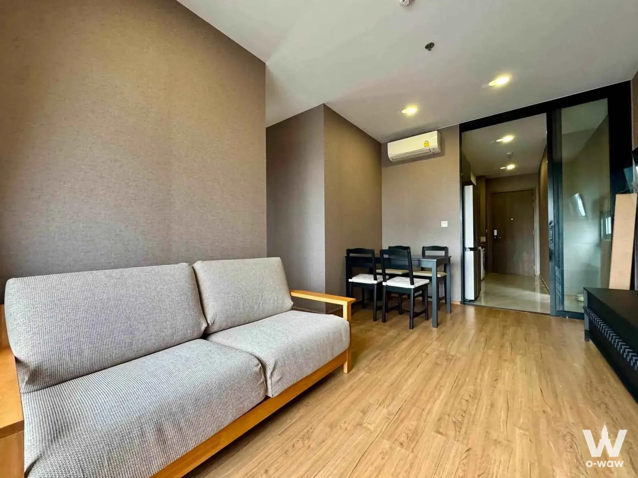 Furnished living room in a 2-bed Cloud Thonglor condo with grey sofa and wood dining set