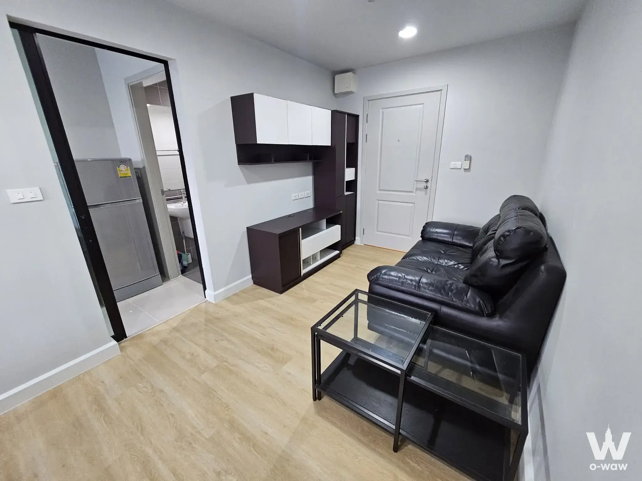 1-bed condo for sale in B-loft sukhumvit 115 with black leather sofa and modern minimalist living room