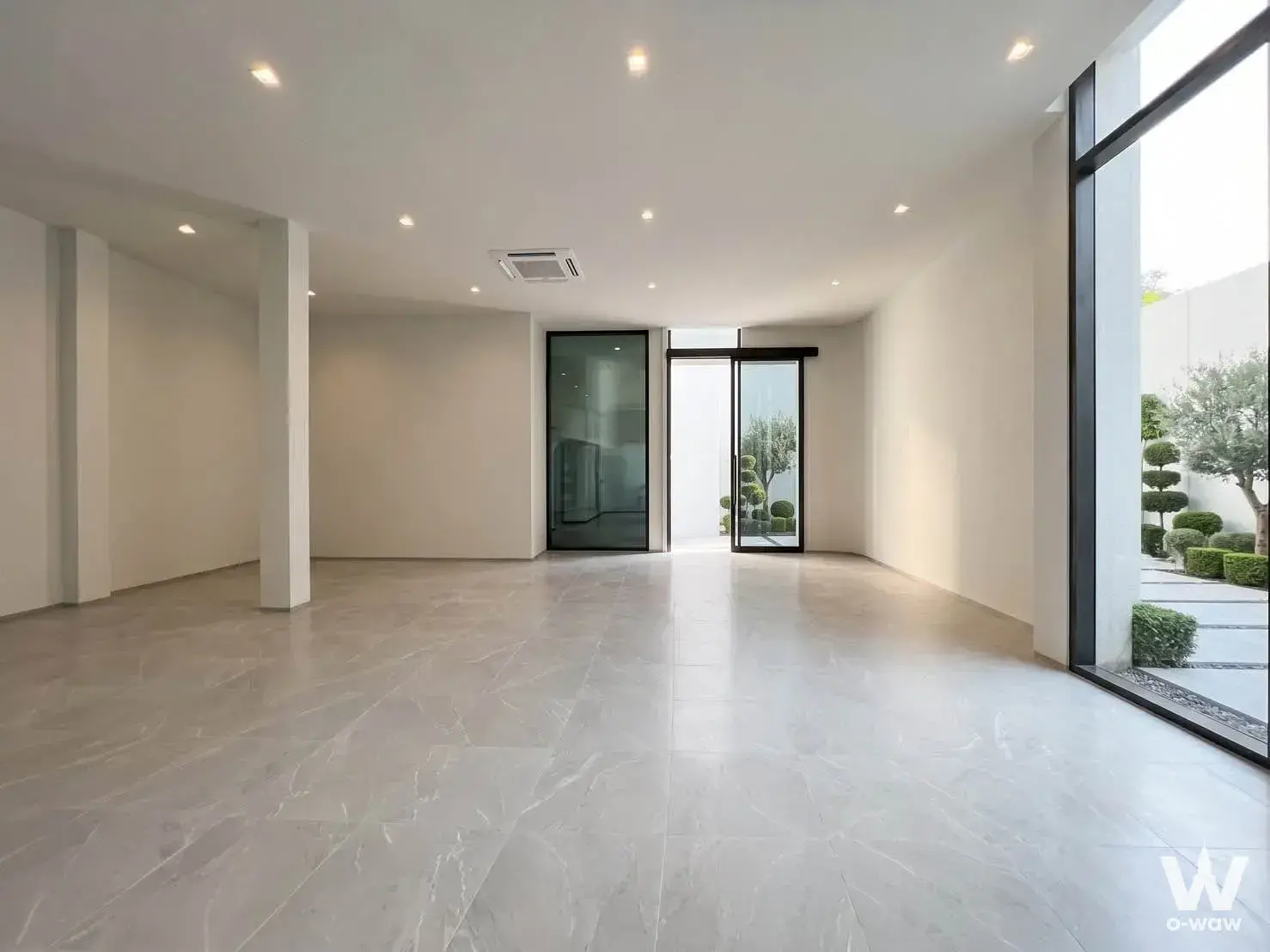 Spacious unfurnished living area in COBE Kaset-Sripatum condo with marble floors and floor-to-ceiling windows overlooking