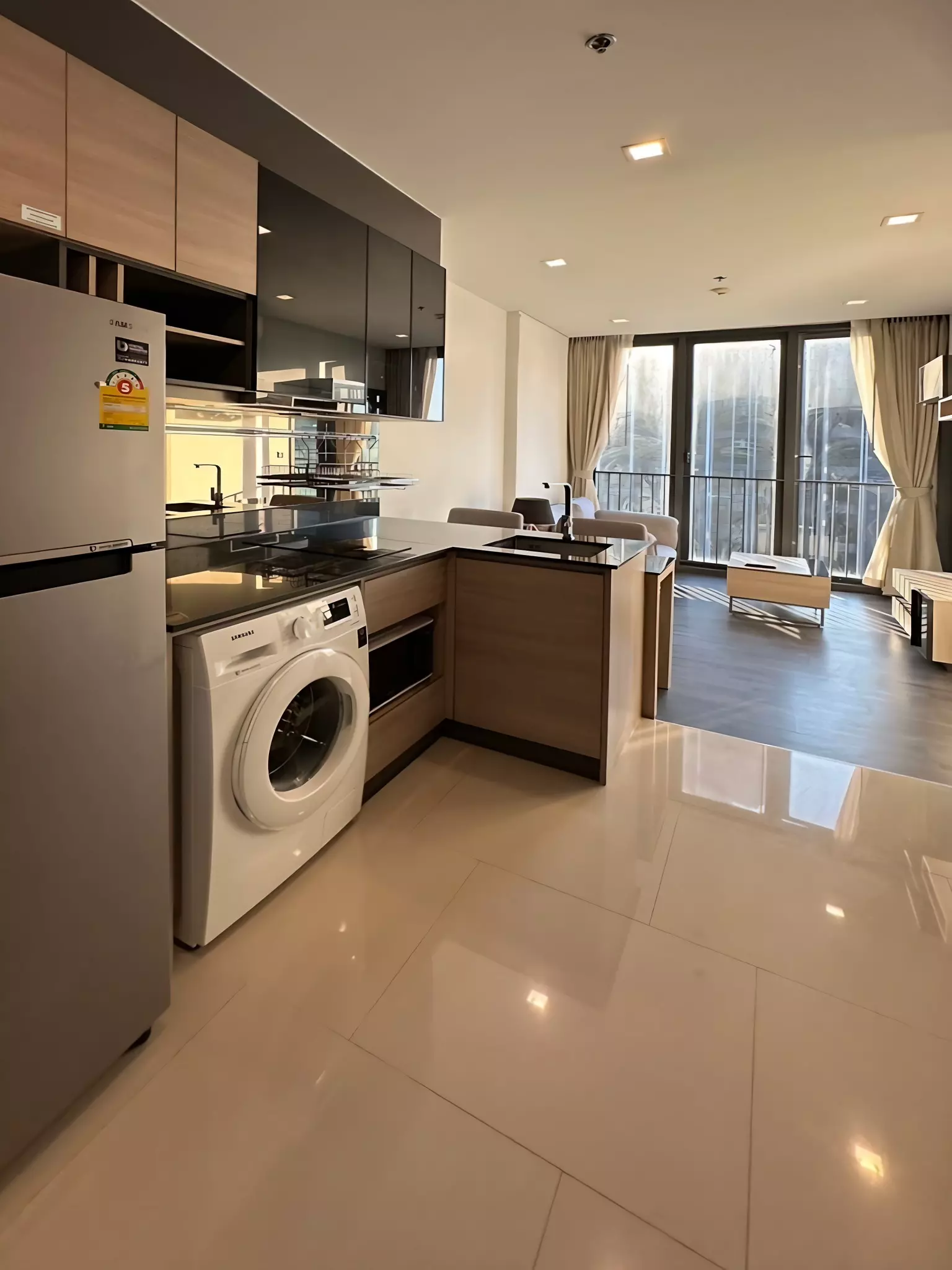 Open-plan kitchen and living area in 1-bed condo for rent at THE LINE Asoke-Ratchada with balcony view