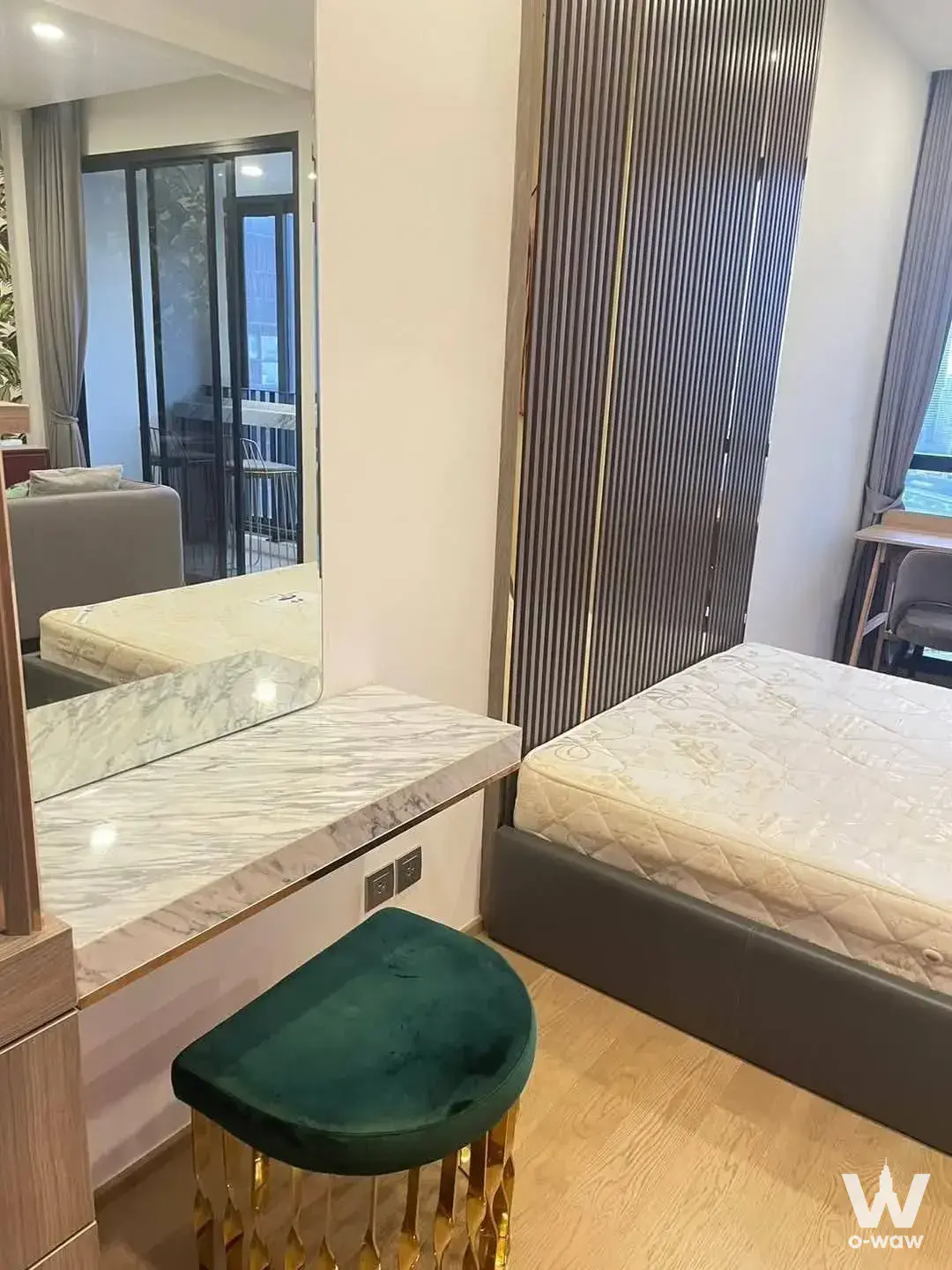 Queen bed, marble vanity, and emerald stool in this 1-bed condo for sale at Ashton Chula-Silom