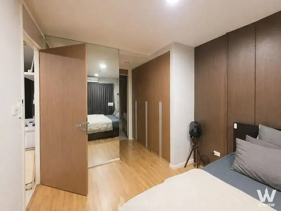 Queen bed and dark wood accent wall in a furnished bedroom at Whizdom The Exclusive