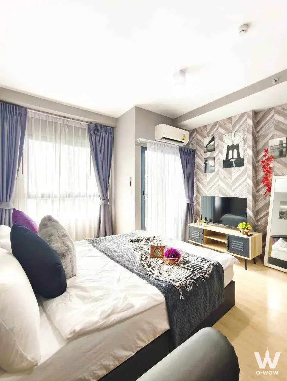 Master bedroom in Ideo New Rama 9 1-bed condo with chevron wall and sheer curtained window