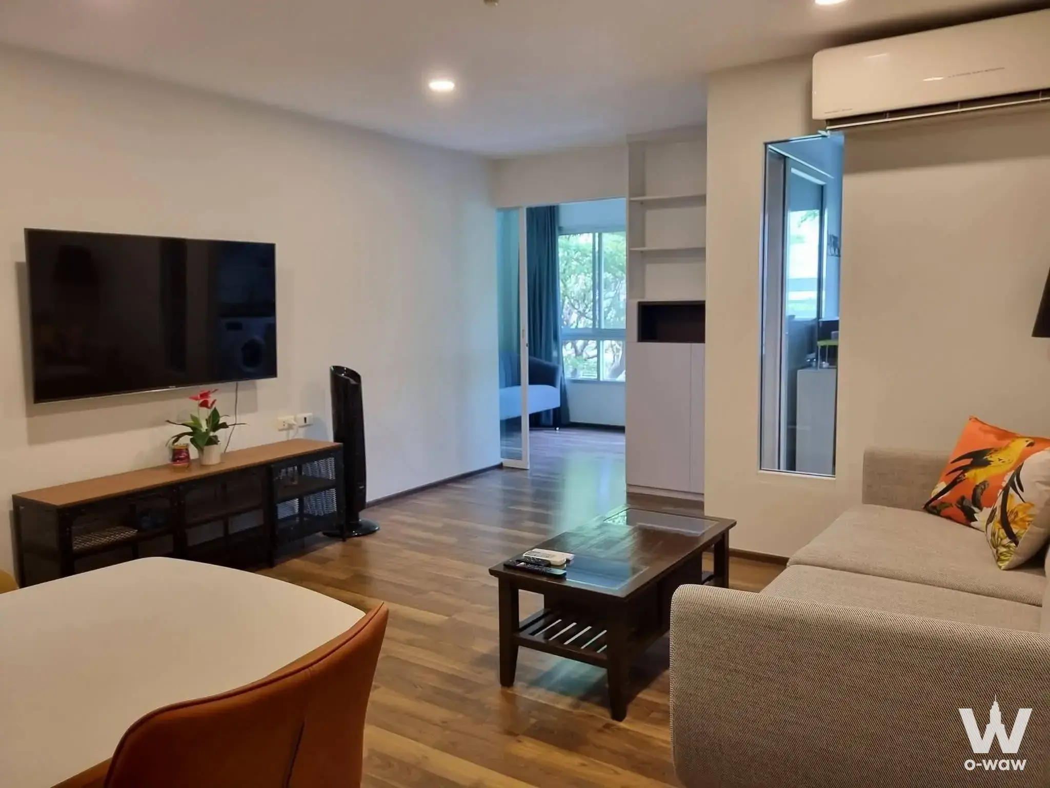 Furnished living space in a 2-bed condo at The Room Sukhumvit 79 with grey sofa and industrial console