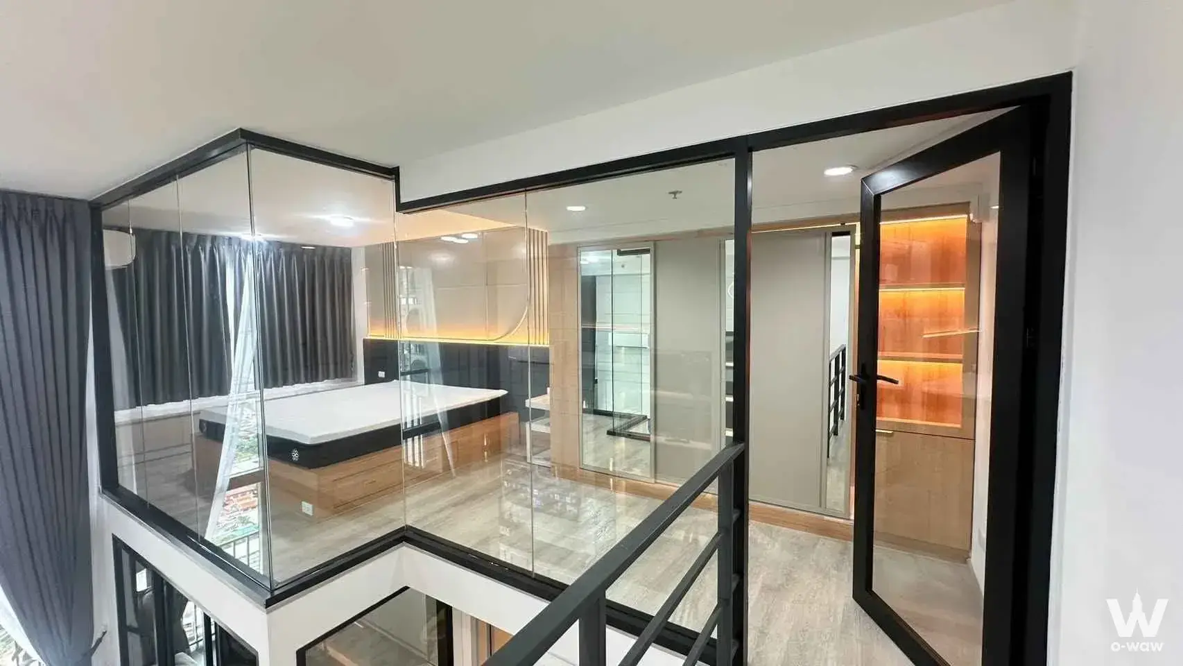 Duplex bedroom with glass partitions and wood flooring at 1-bed condo for rent in Ideo Charan 70 Riverview Bangkok