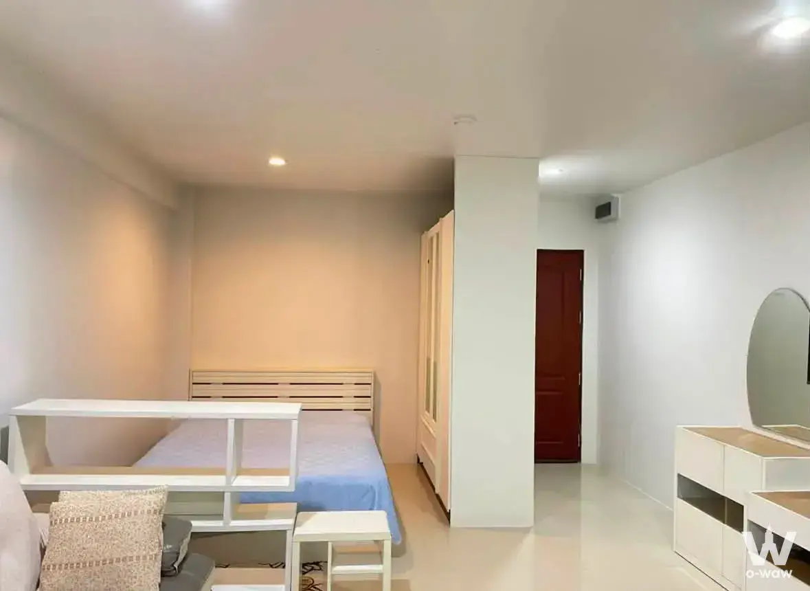 Studio bedroom with blue accents in Grand Park Town condo for sale