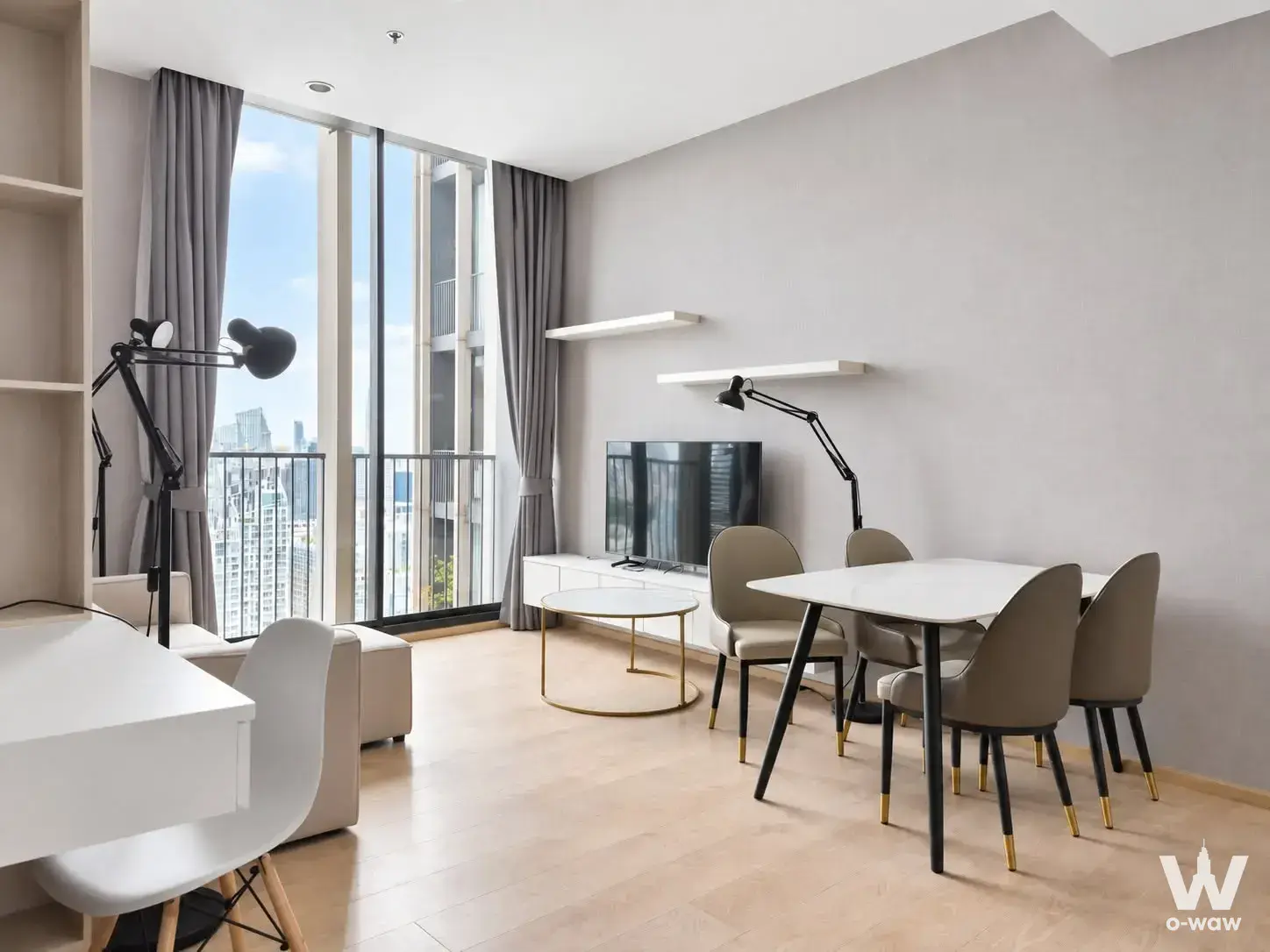 Open-plan living room of a 2-bed condo for rent in Noble BE19 with floor-to-ceiling glass doors and city skyline view