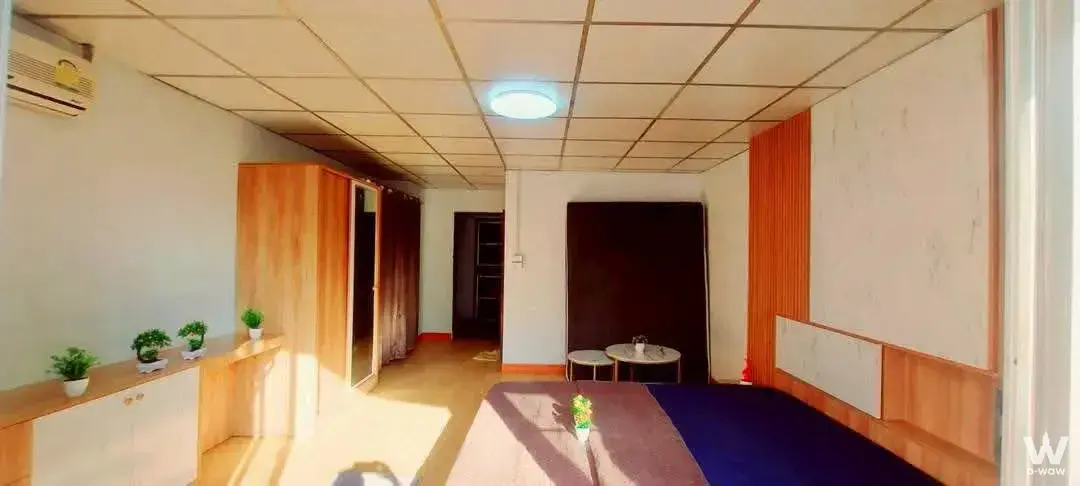Budget-friendly 1-bed condo for sale in ภัทรคอนโด bedroom features white walls, wood slat paneling, and blue bedding with