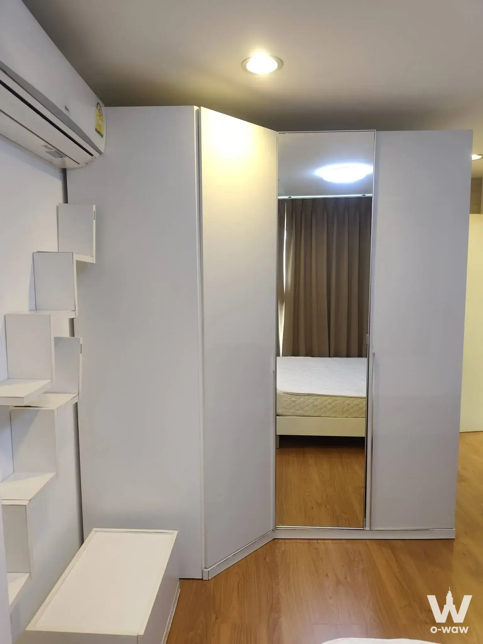 Furnished 2-bed condo for sale in Kon Do Wan Ratchada-Ladprao, highlighting a bedroom with mirrored wardrobe, warm wood