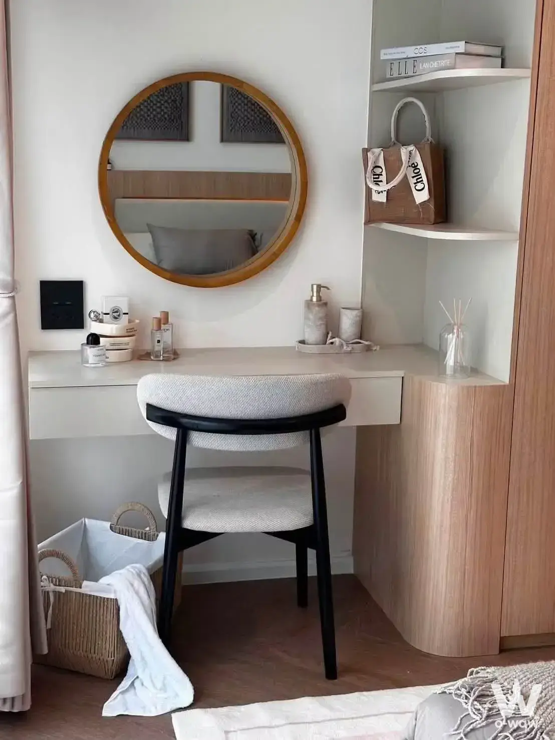 Bedroom vanity with white floating desk, round mirror, and woven basket in Viengping Mansion condo