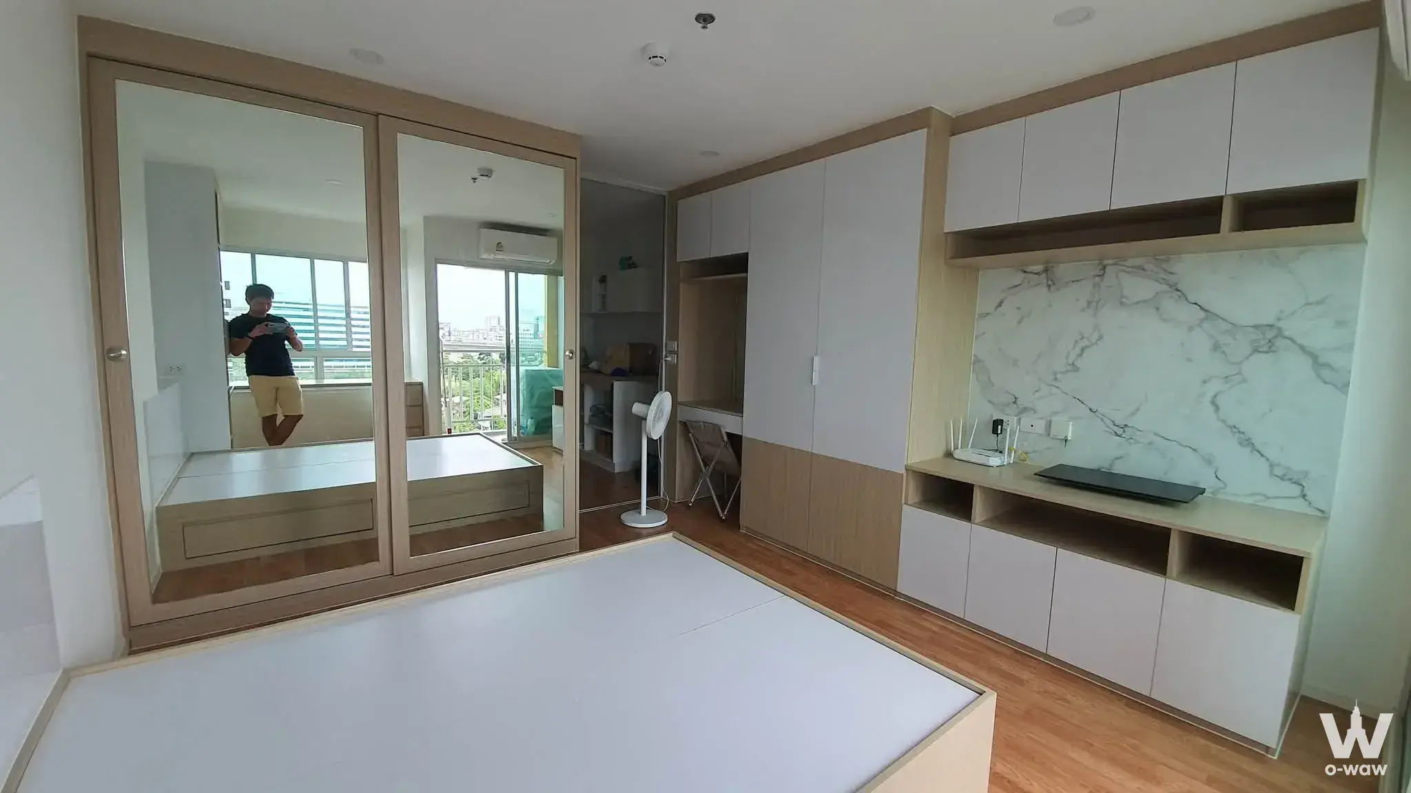 Modern bedroom with two-tone built-in wardrobes and marble TV unit in Lumpini Ville Pattanakarn condo for sale