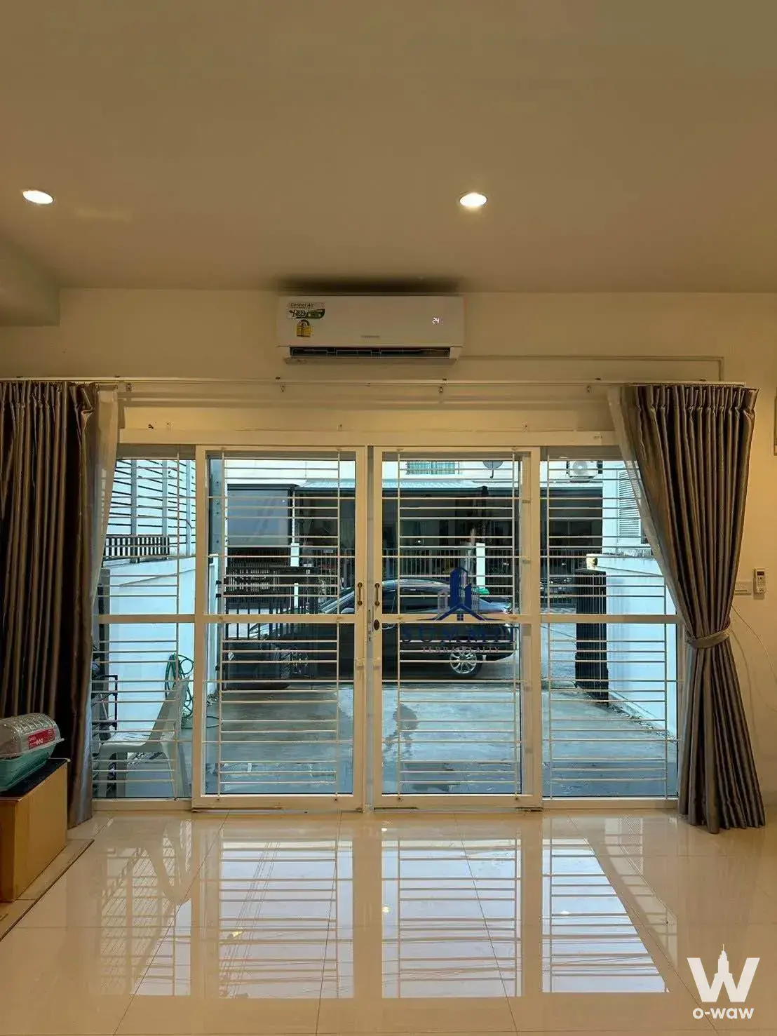 Cityhome Ratchada-Pinklao empty living room with glossy tile floor, AC unit, and courtyard view