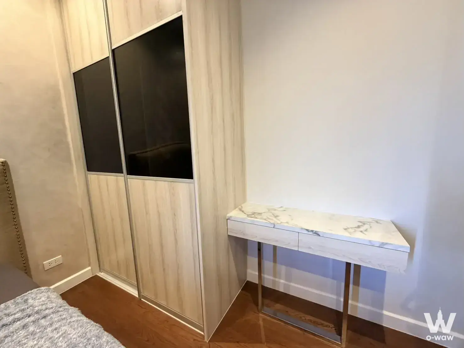 Modern bedroom corner with oak wardrobe and marble console in 1-bed condo for sale at Mayfair Place Sukhumvit 50