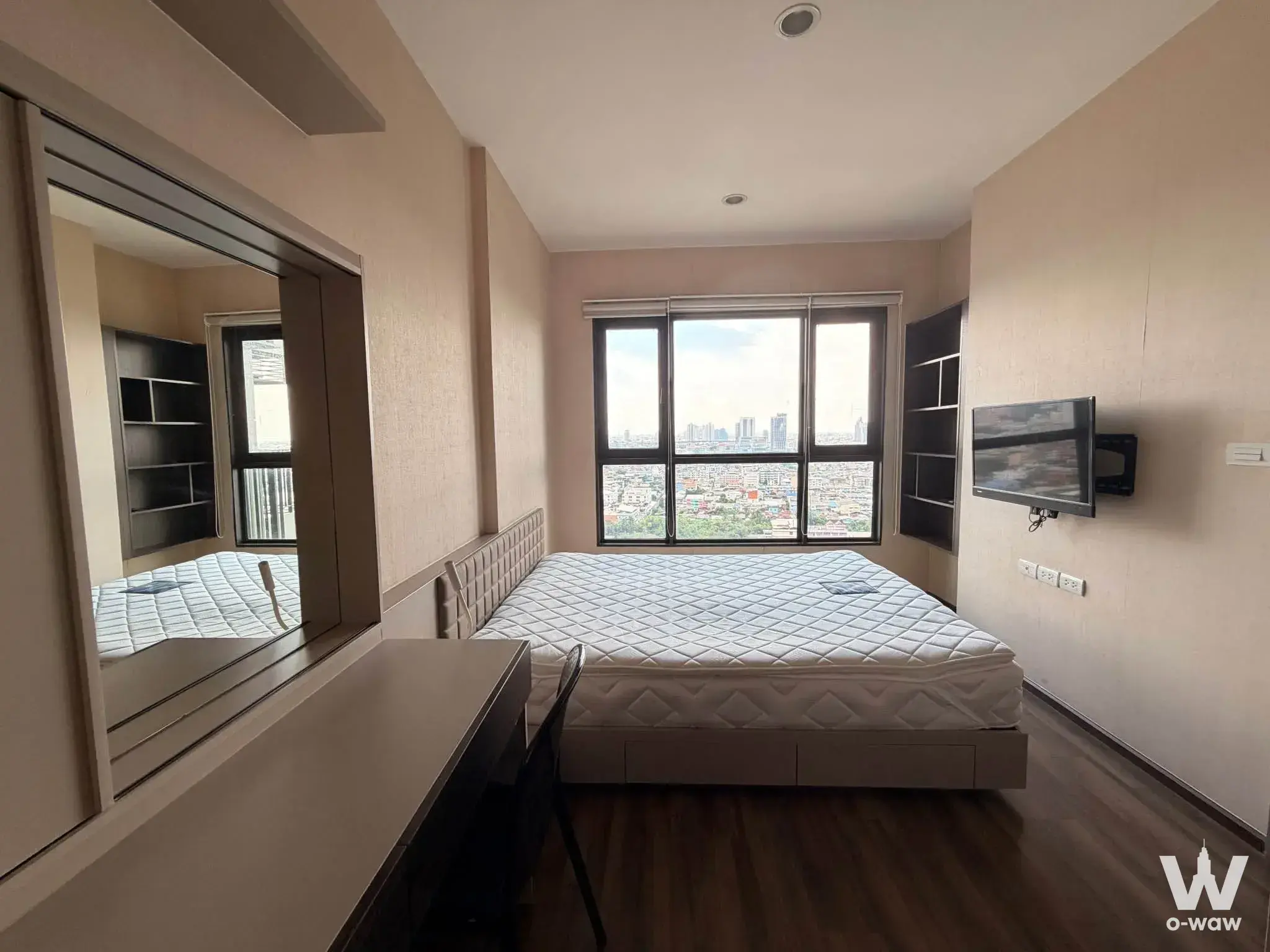 Queen bed and city skyline view in a 1-bed condo for rent in Teal Sathon-Taksin