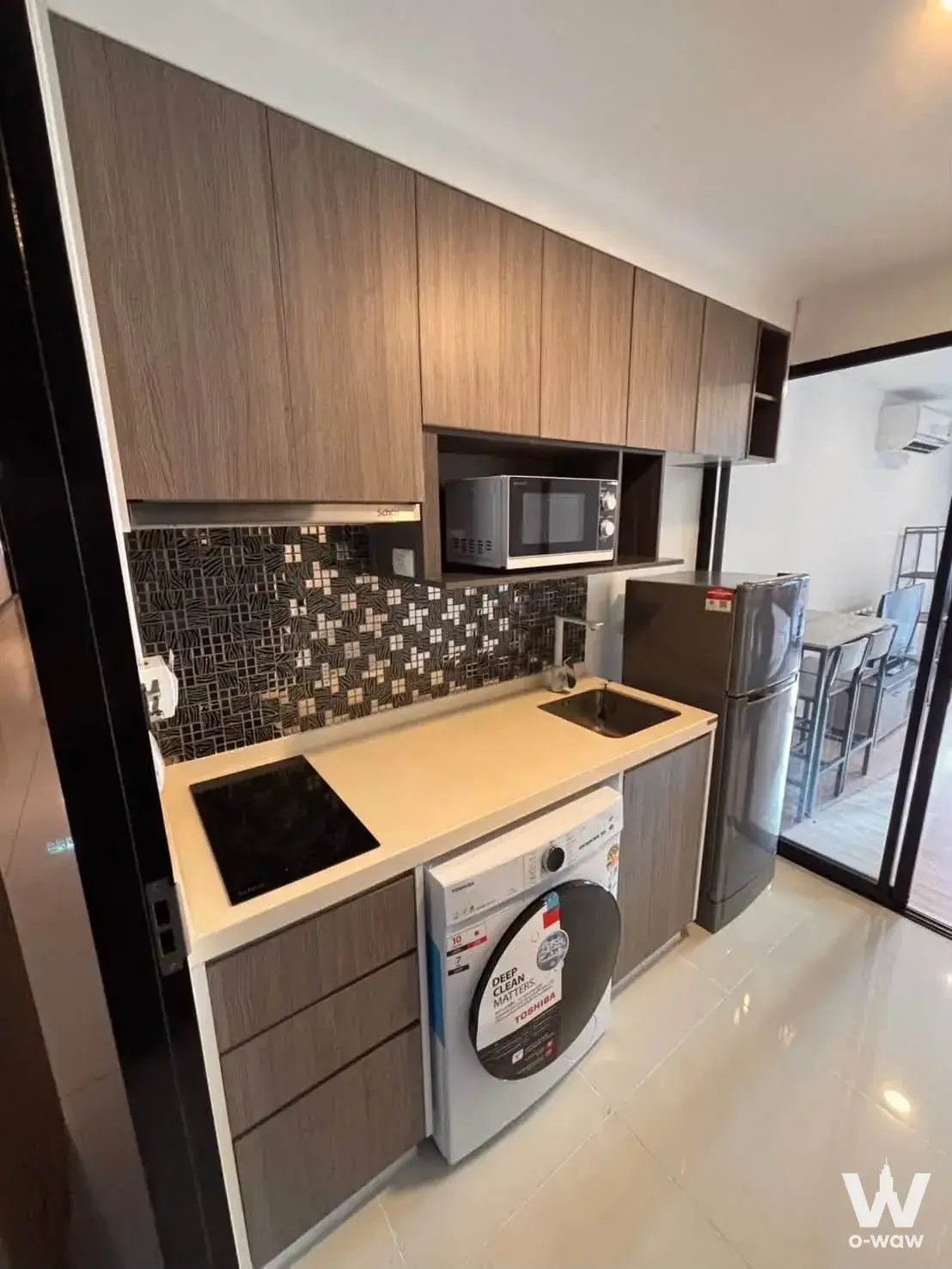 Modern 1-bed condo kitchen in Chateau In Town Pinklao with grey-brown cabinets and mosaic backsplash