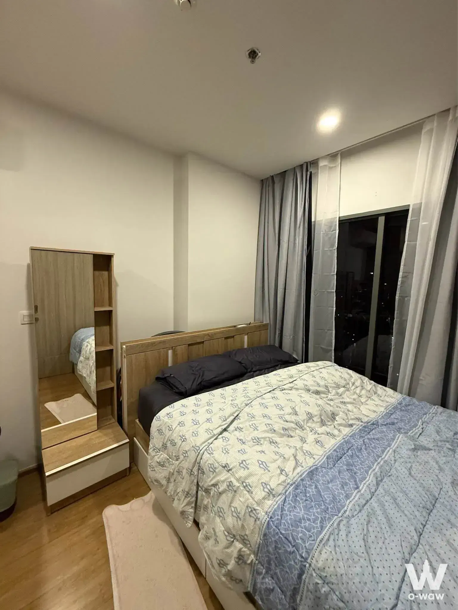 Bedroom featuring light wood wardrobe and blue patterned bedding in a Cloud Thonglor-Phetchaburi condo