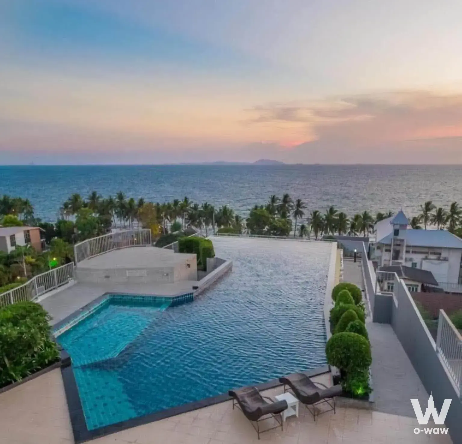 The Patio Bangsaen rooftop infinity pool with ocean sunset view and lounge chairs