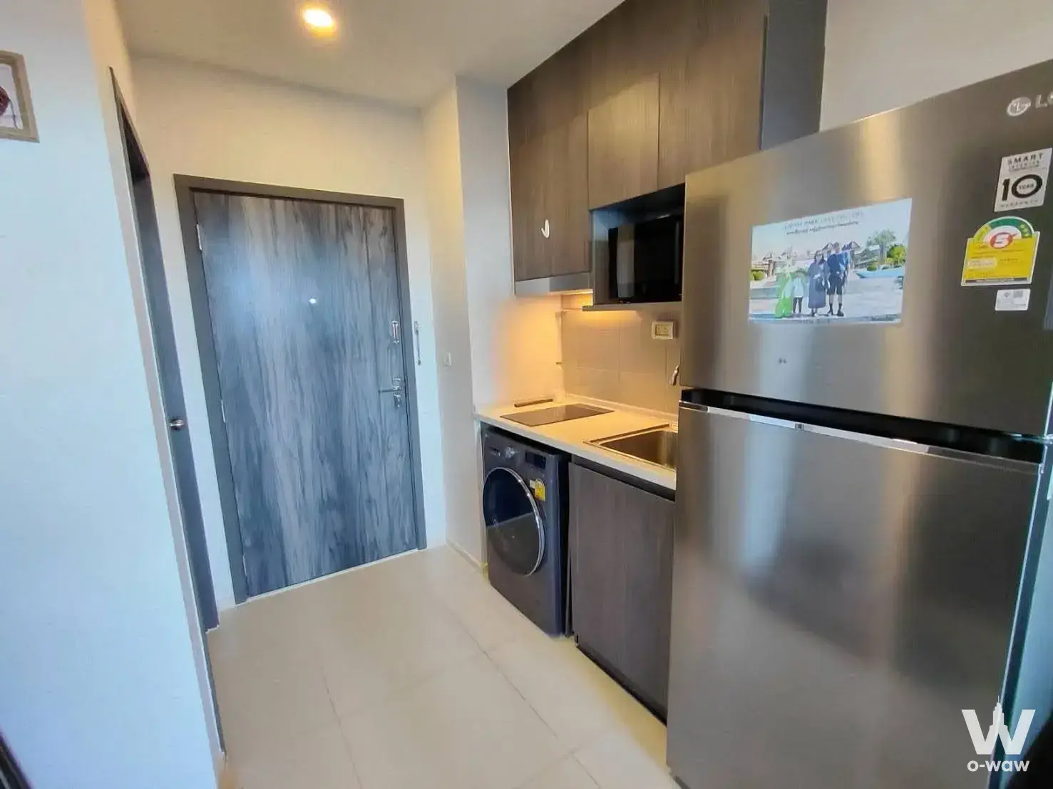 Compact kitchenette in ELIO DEL NEST 2-bed condo featuring dark wood cabinets and a double sink
