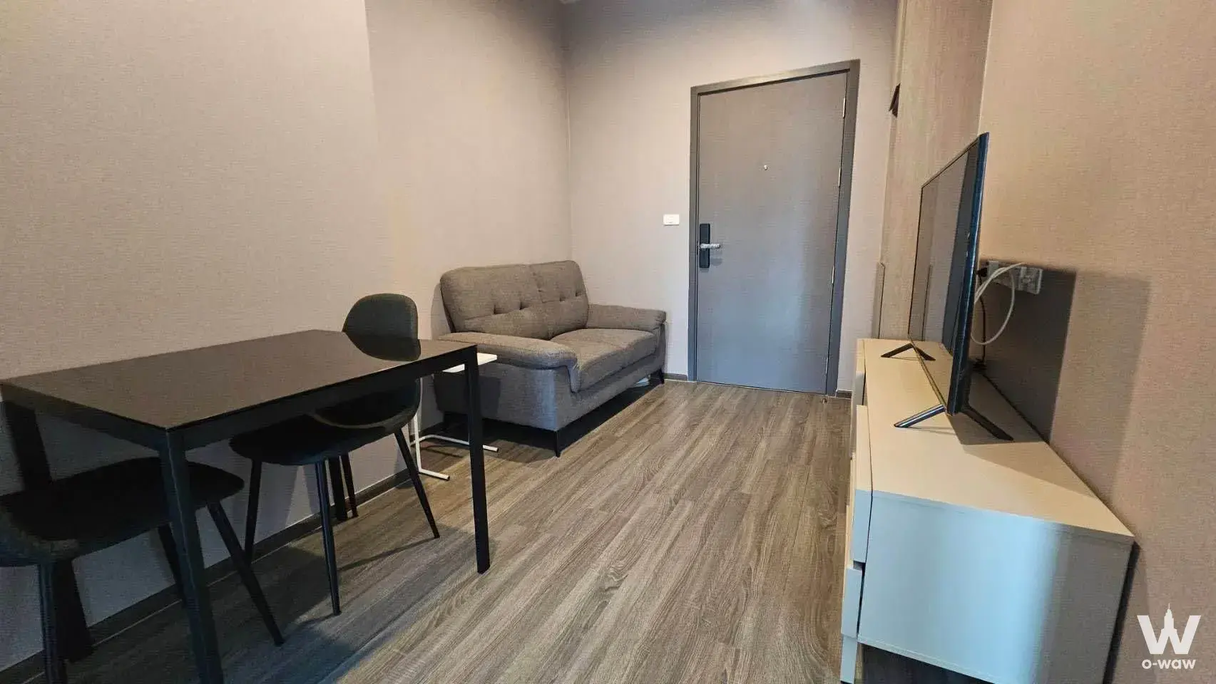Modern 1-bed condo living area in Ideo Ramkhamhaeng Lamsali Station with grey sofa and dining set