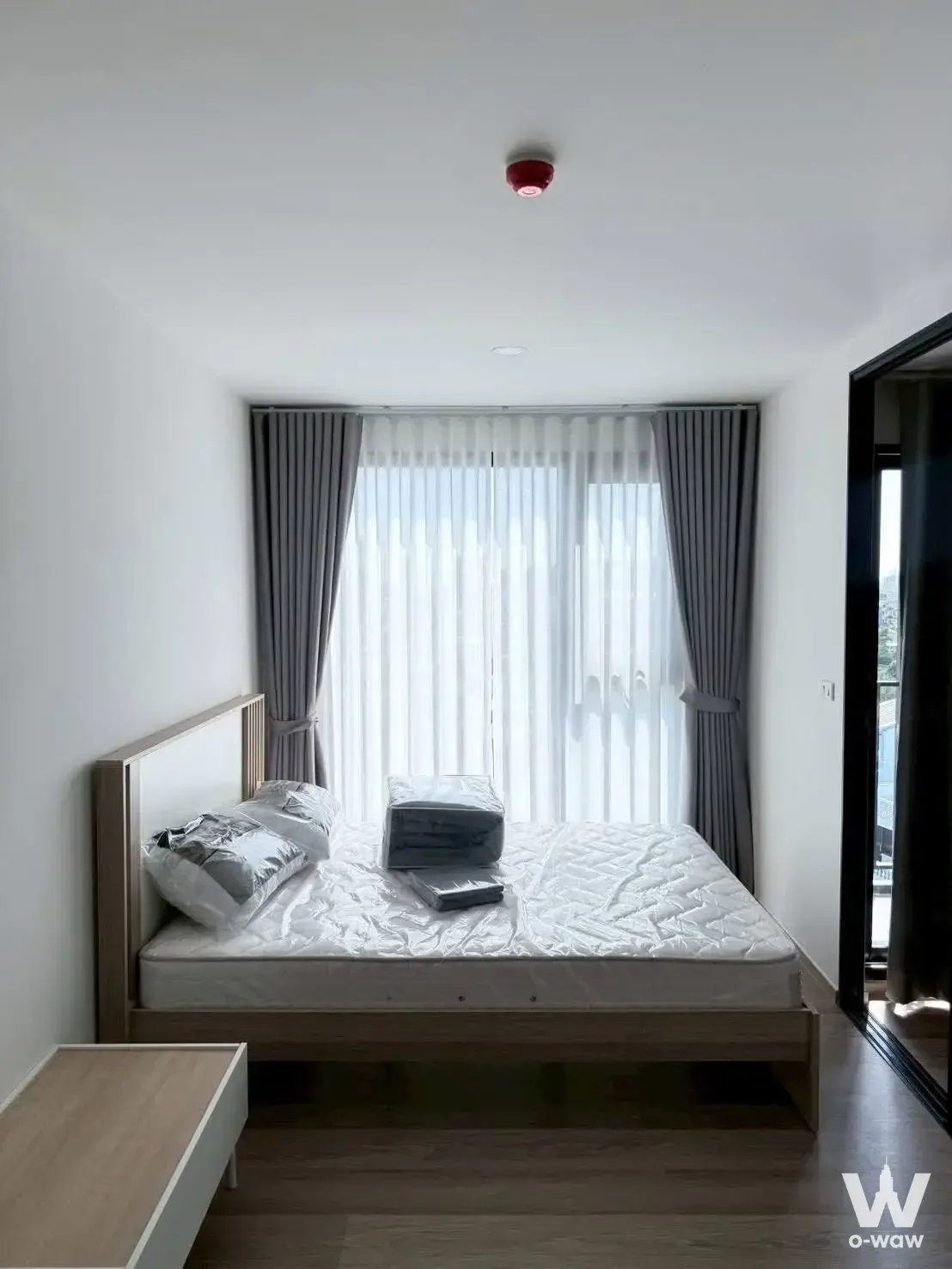 Bright 1-bed condo bedroom in Origin Play Bangkhunnon with wood floors, queen bed, and balcony access