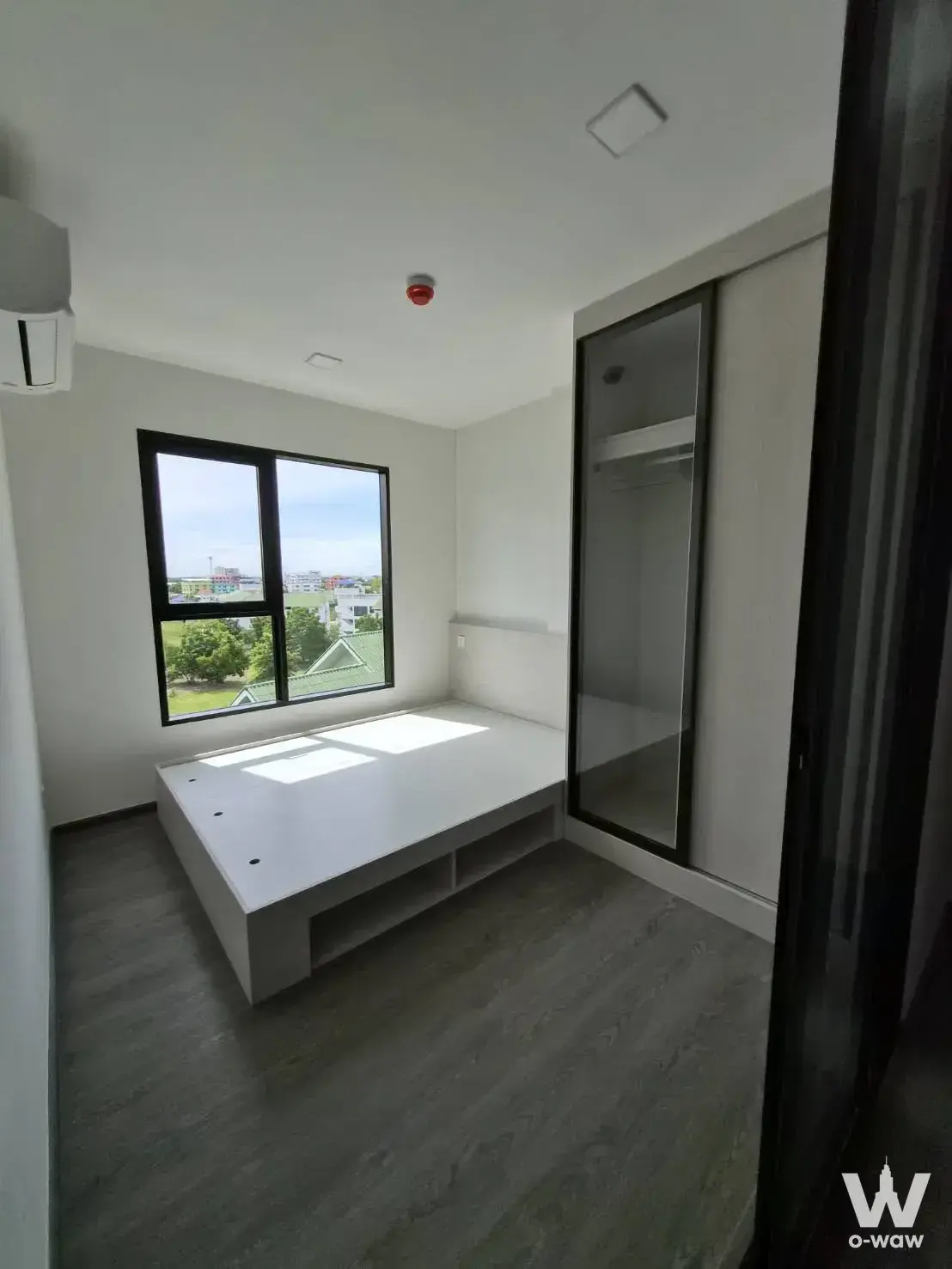 Unfurnished bedroom in 1-bed Kave Wonderland condo with platform bed, wardrobe, and window view