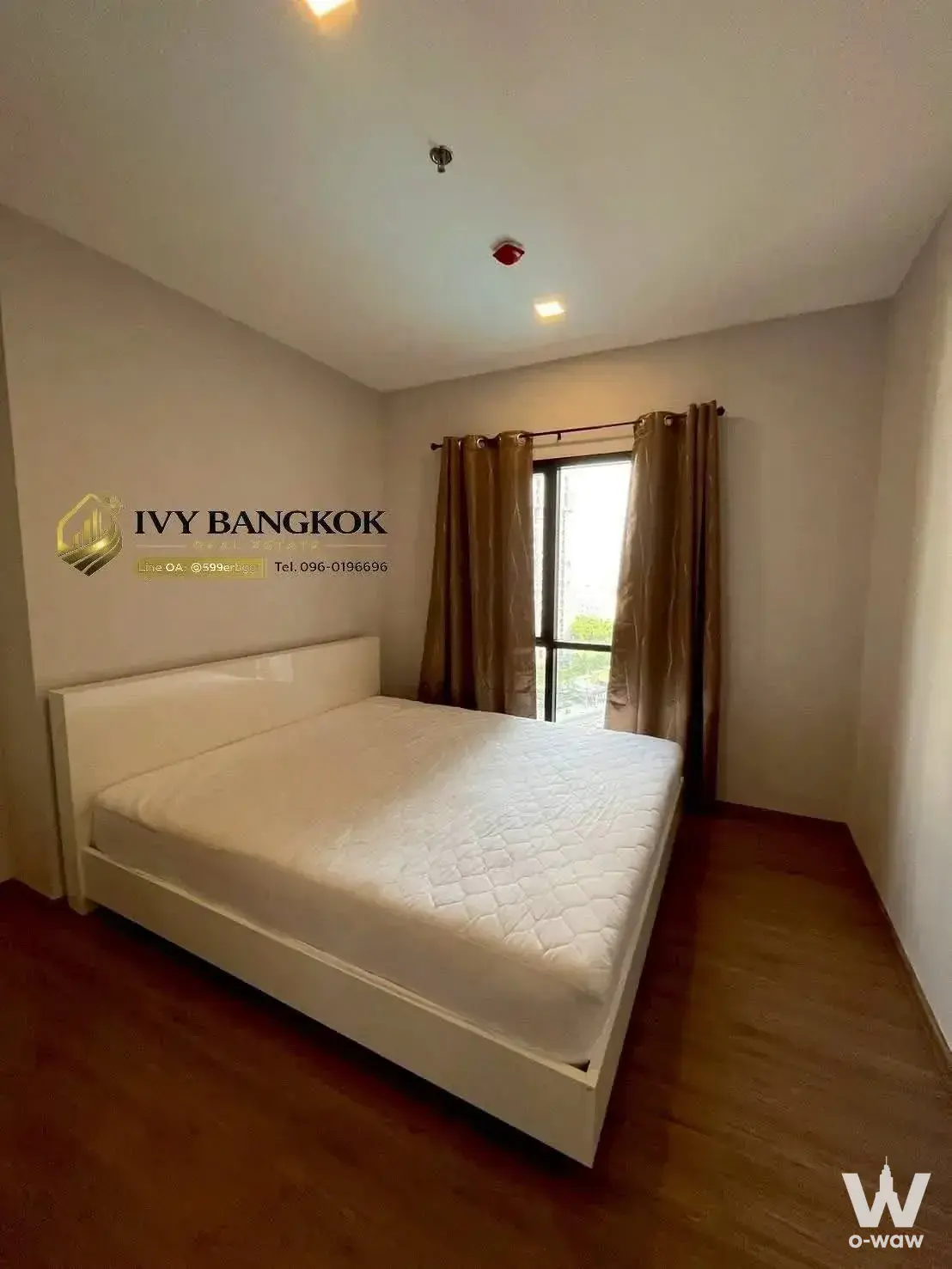 Spacious bedroom with wood floors and large window in 2-bed condo for rent at Metris Rama 9-Ramkumhang
