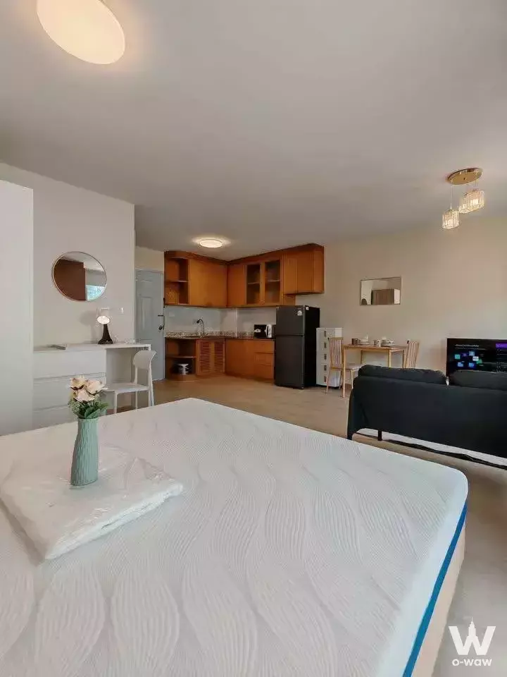 Queen bed, kitchenette and dining area in this 1-bed condo for rent at The Parkland Bangna
