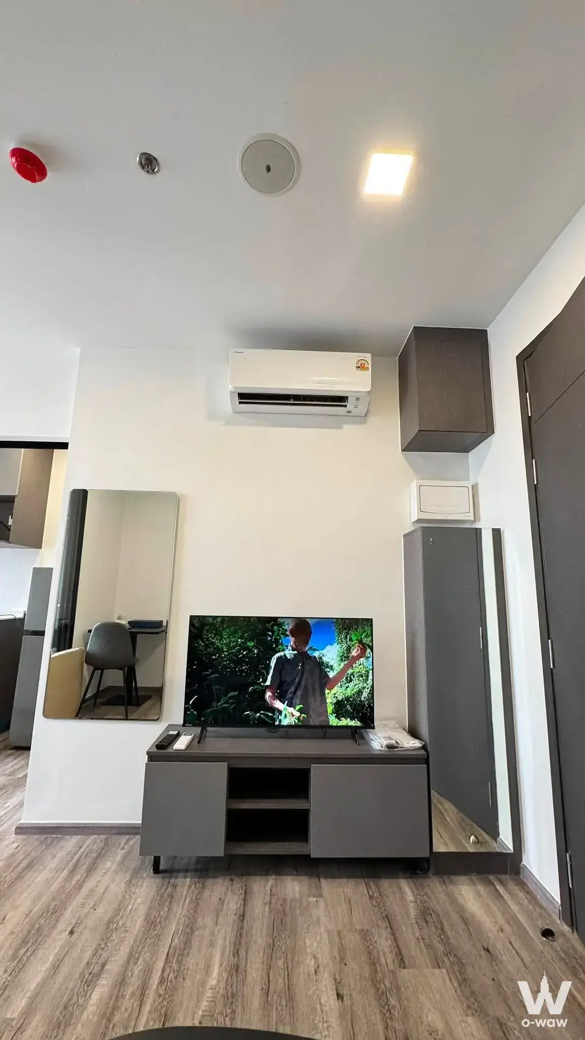 Modern living room in 1-bed Modiz Vault Kaset Sripatum condo with TV console, AC, and mirrored wardrobe