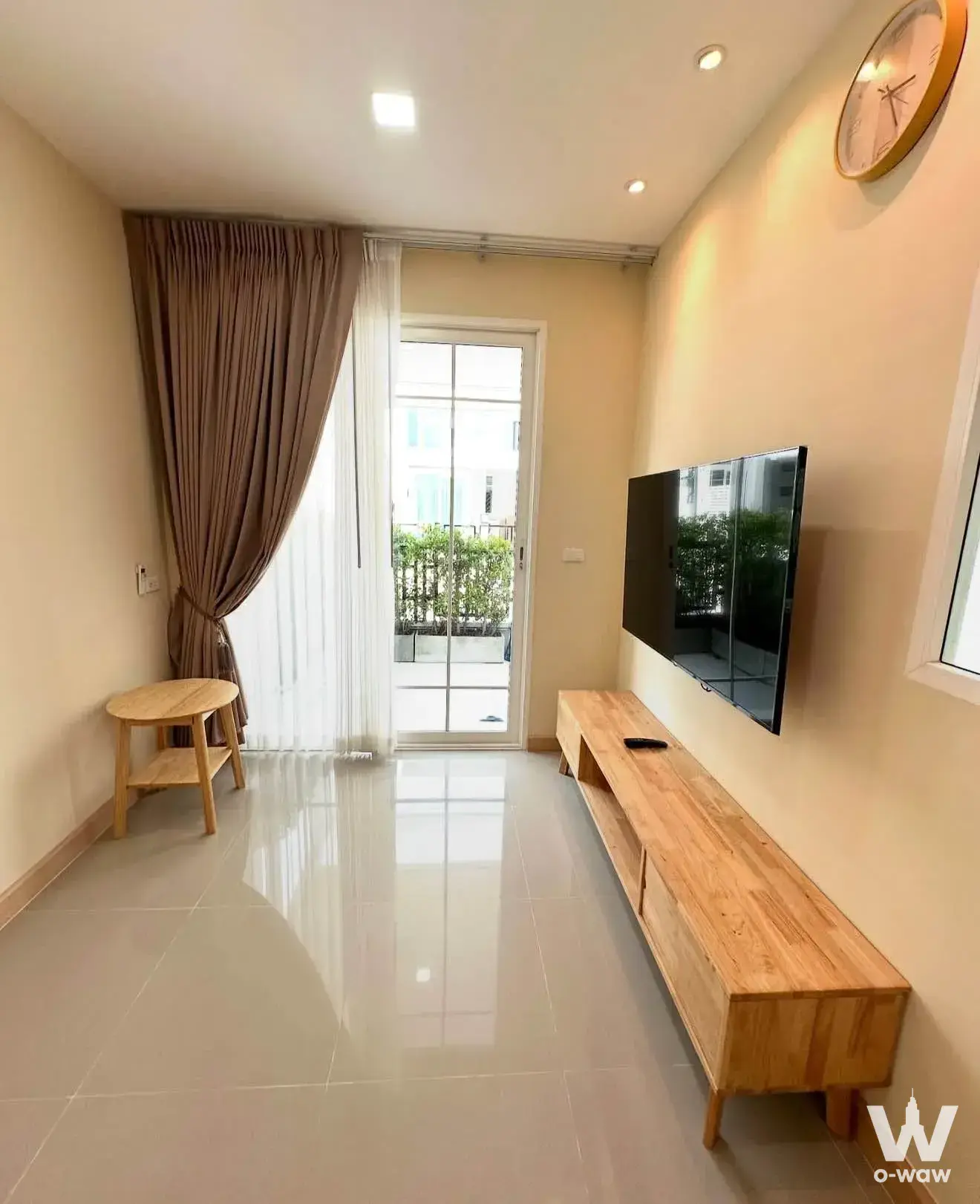 Bright living room in a 3-bed house for rent at Golden Neo Sukhumvit-LaSalle featuring wood console and balcony