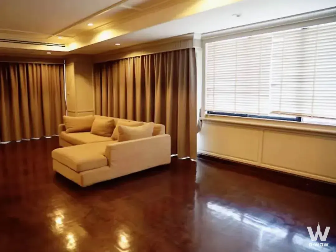 3-bed condo for sale in PM Riverside showcasing spacious living room with cream sectional sofa, polished hardwood floors,