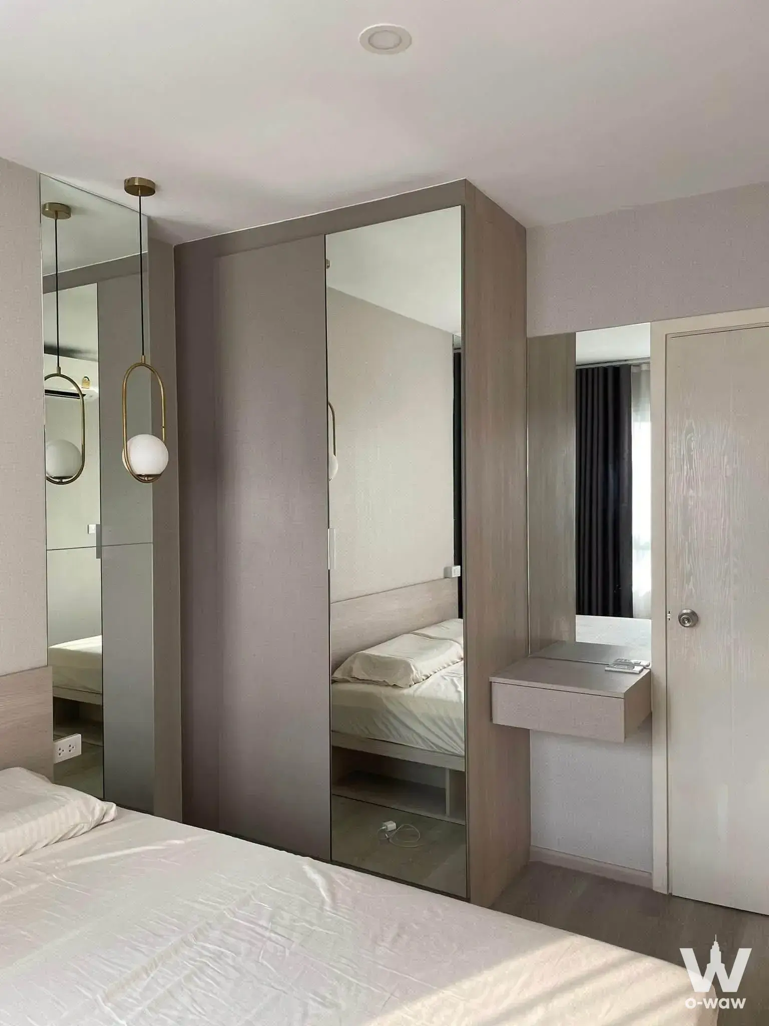 Modern bedroom in Elio Sathorn-Wutthakat featuring grey wardrobe and gold pendant light
