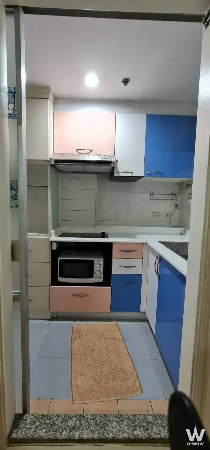 Compact 2-bed condo kitchen in Lumpini Place Rama 8 with colorful blue and pink cabinetry