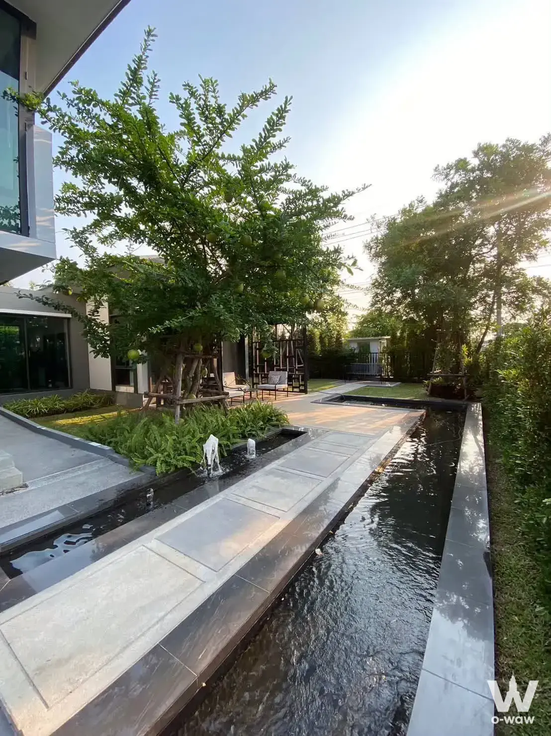 Modern villa exterior with water feature garden for sale in Setthasiri Thawiwatthana
