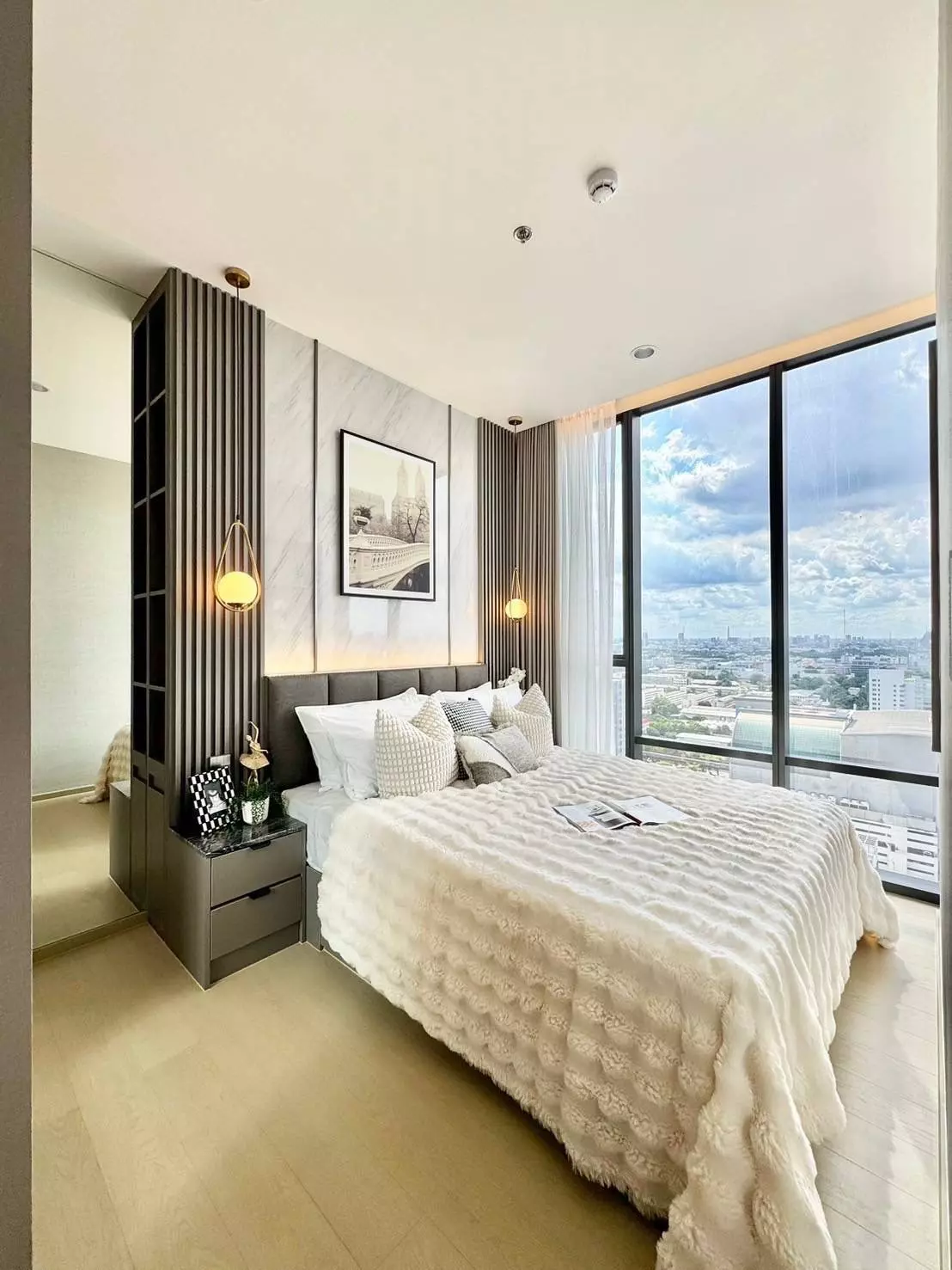 Modern bedroom in THE EXTRO Phayathai-Rangnam 1-bed condo for rent with city views and wood accents