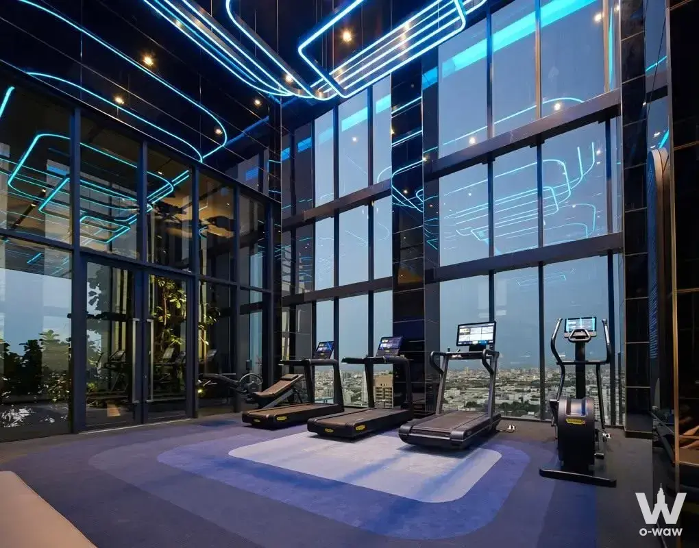 Luxury gym in THE EXTRO Phayathai-Rangnam with mirrored walls and twilight skyline view