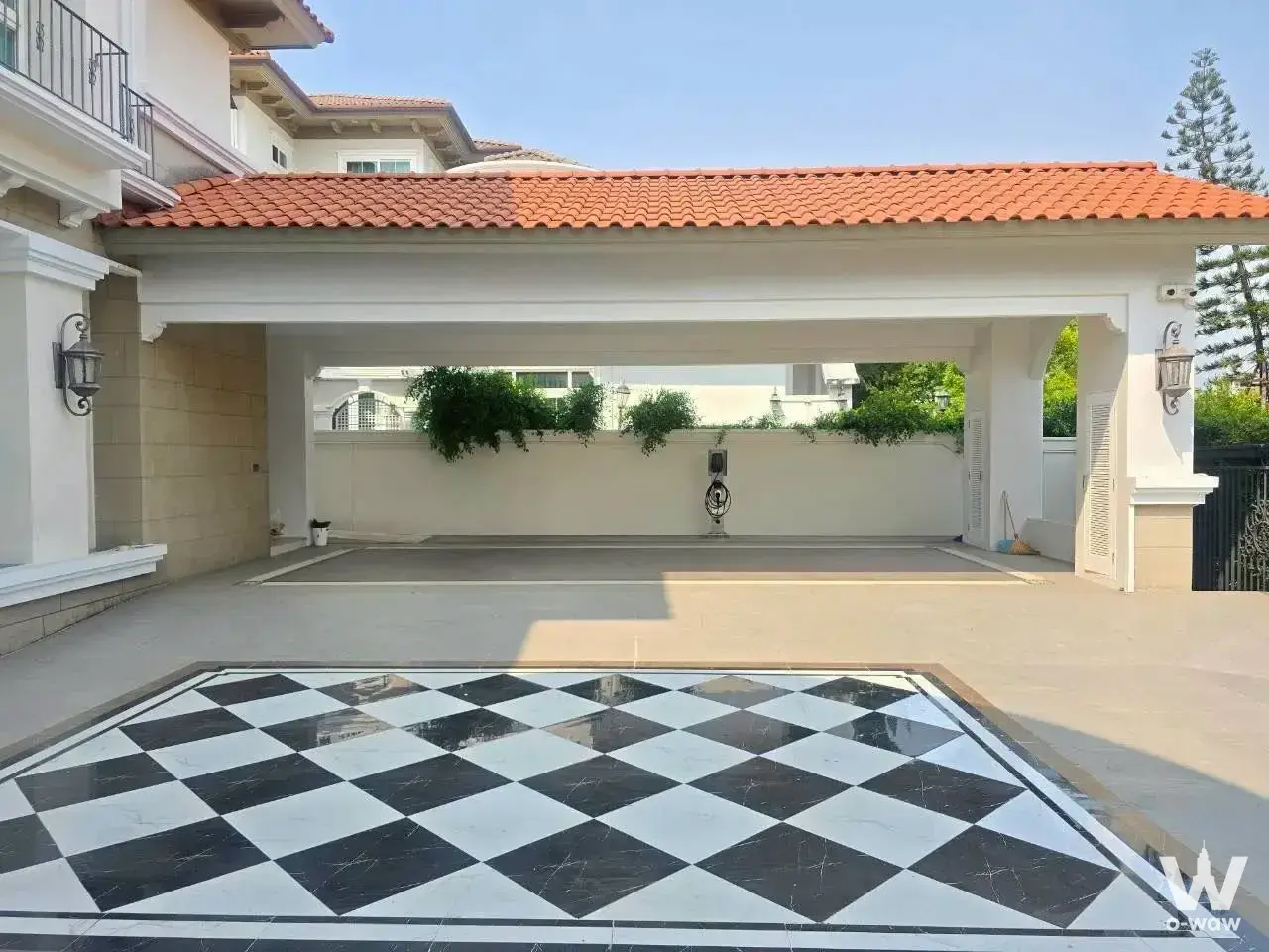 The carport of a 5-bed house for sale at Ladawan Rama 2 has a marble checkerboard floor and clay tile roof