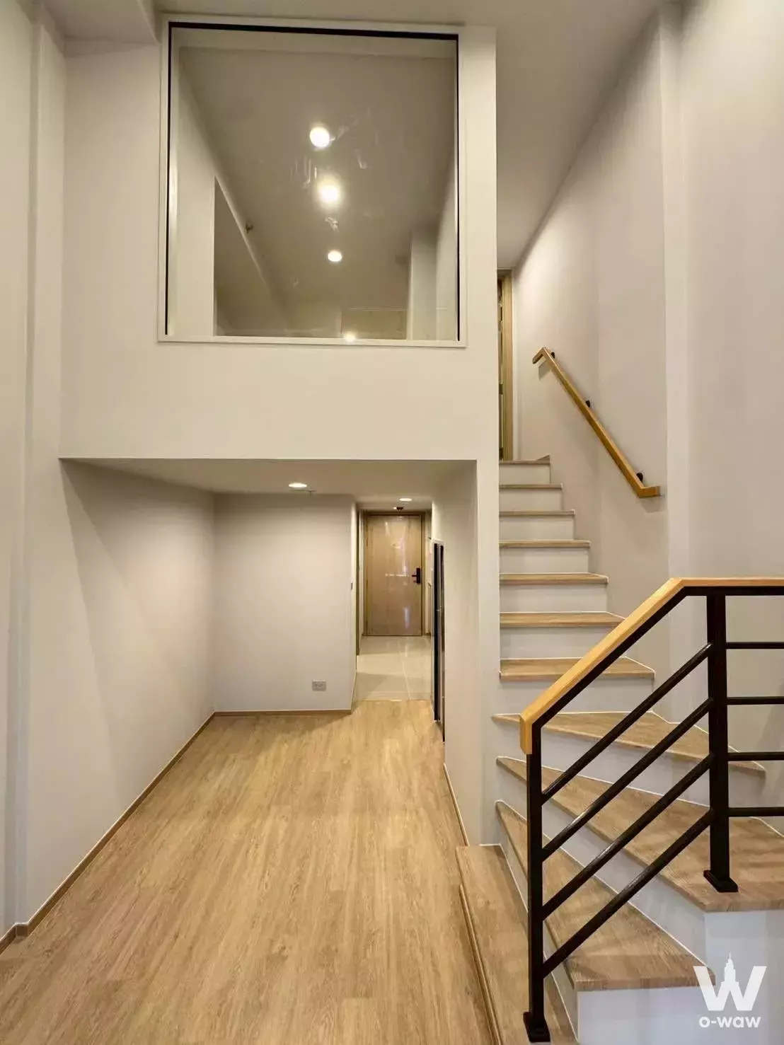 Bright hallway with floating staircase in 1-bed duplex for sale in Culture Chula
