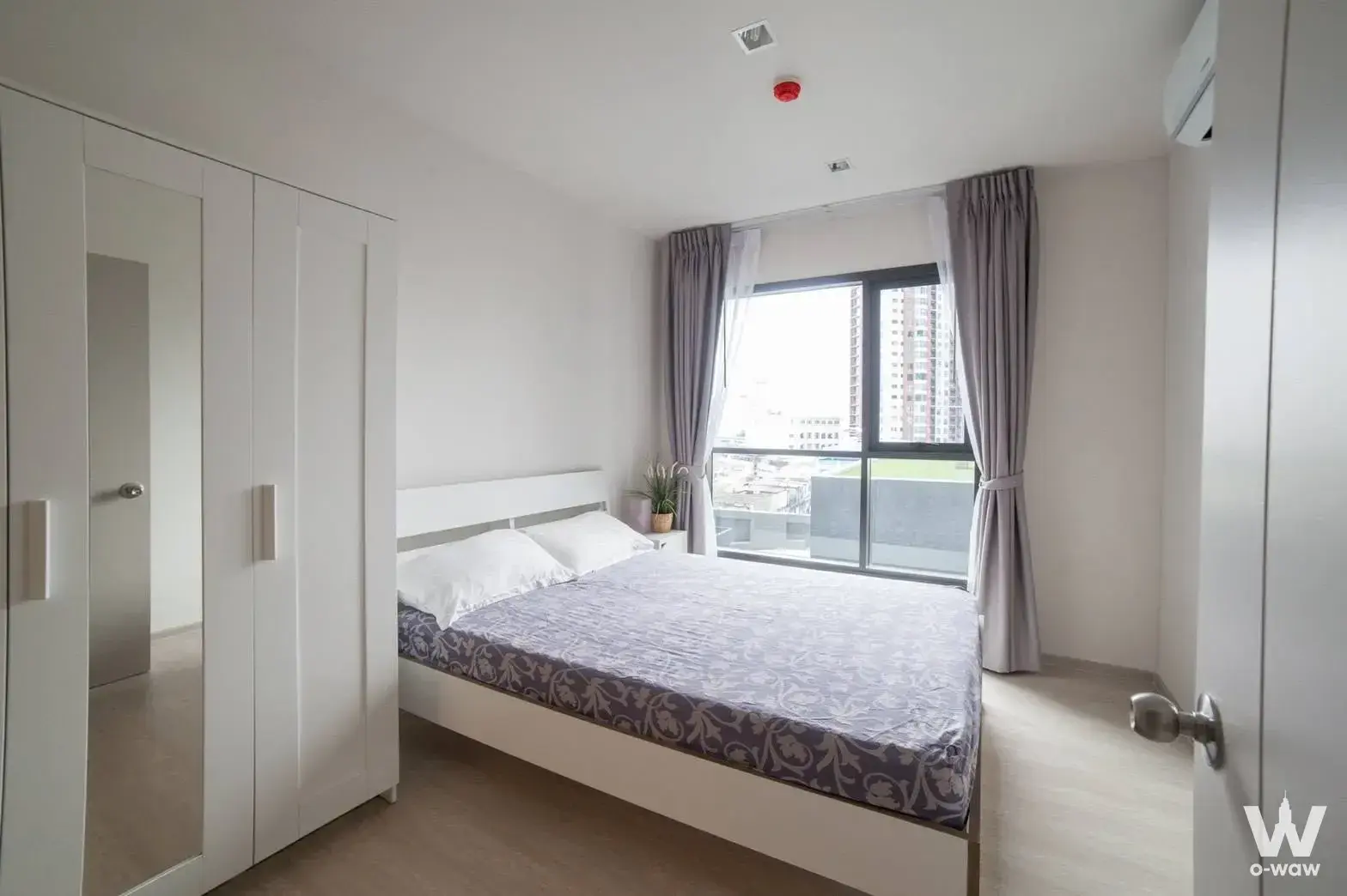 Bedroom in a Life Sukhumvit 48 one-bedroom rental with a white wood bed and a high-floor city view