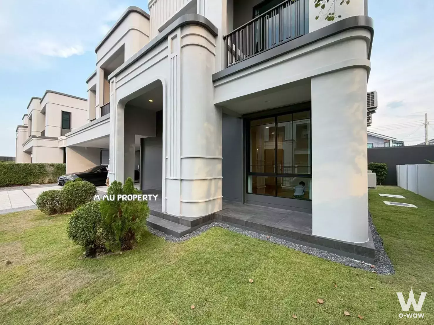 Modern 4-bed house for sale in Setthasiri Wongwaen-Chatuchot with cream facade, carport, and glass doors