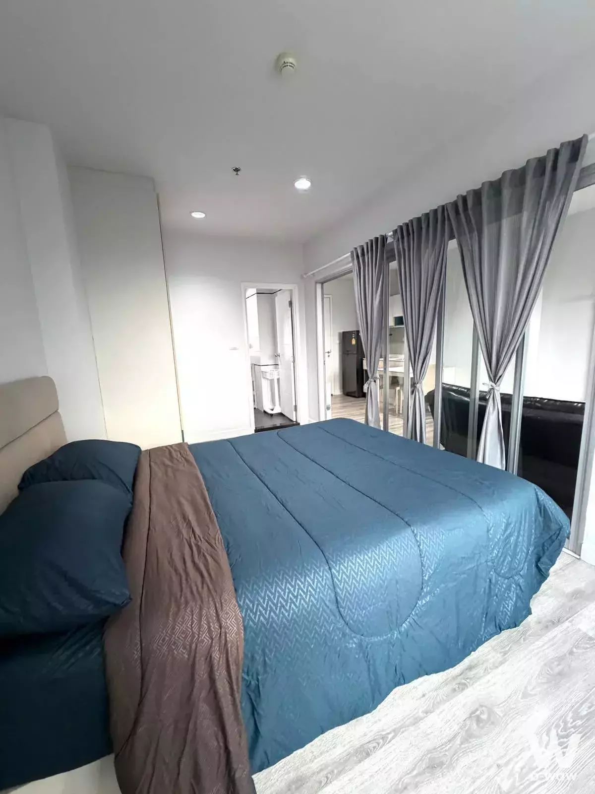 Modern bedroom in 1-bed condo for rent at Centric Sea Pattaya with teal bedding and balcony access