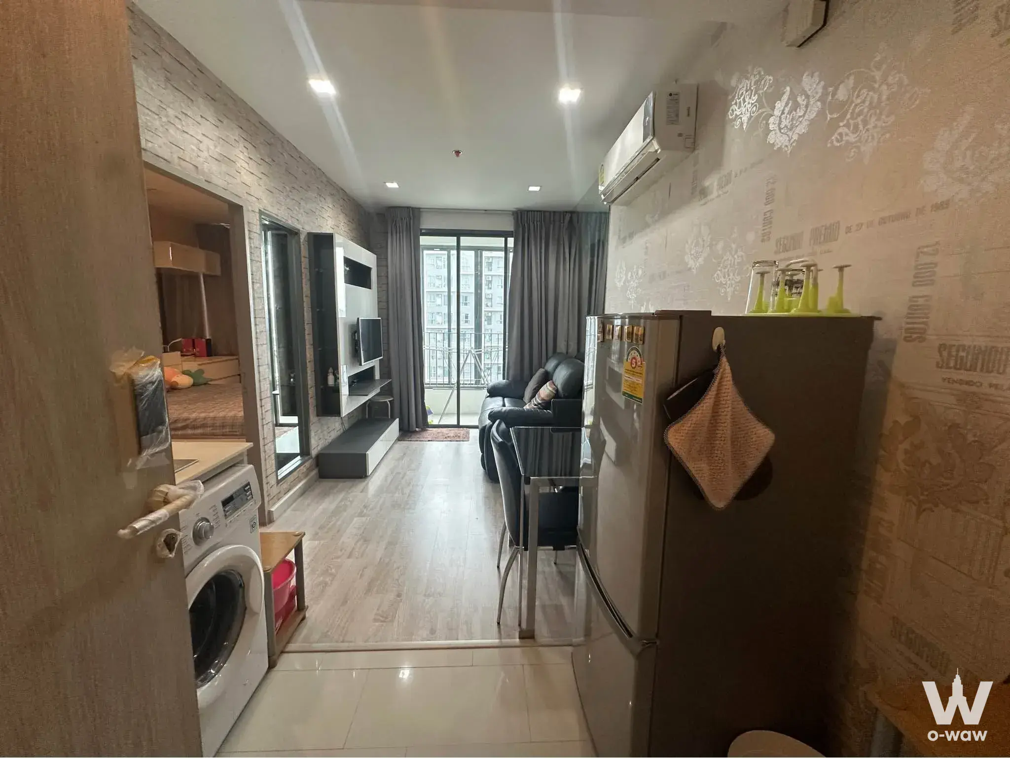 Furnished 1-bed studio in Ideo Mobi Sukhumvit 81 featuring grey faux-brick wall and city view