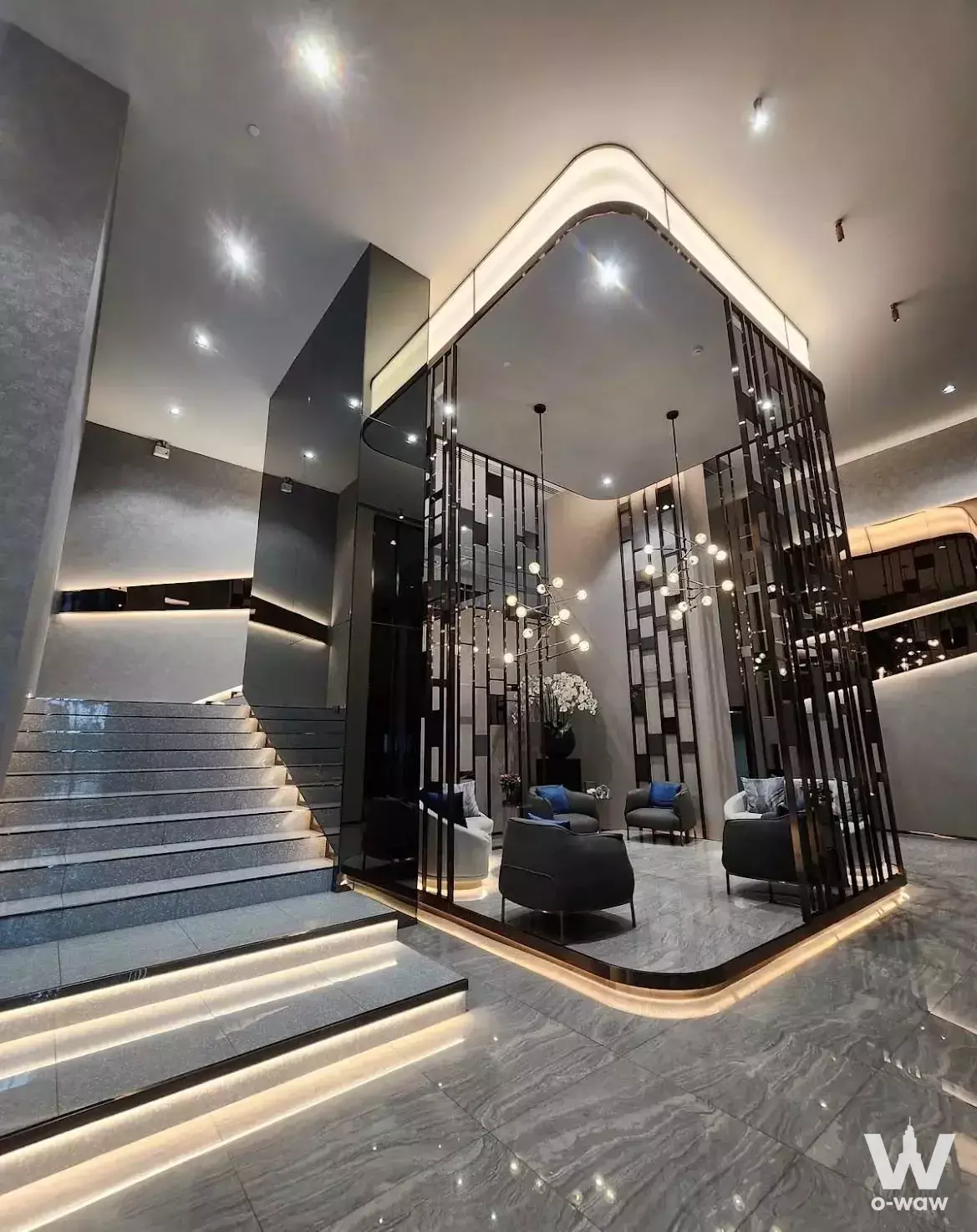 Modern lobby with grey marble floors and LED-lit staircase in Life Asoke Rama 9 condo for rent