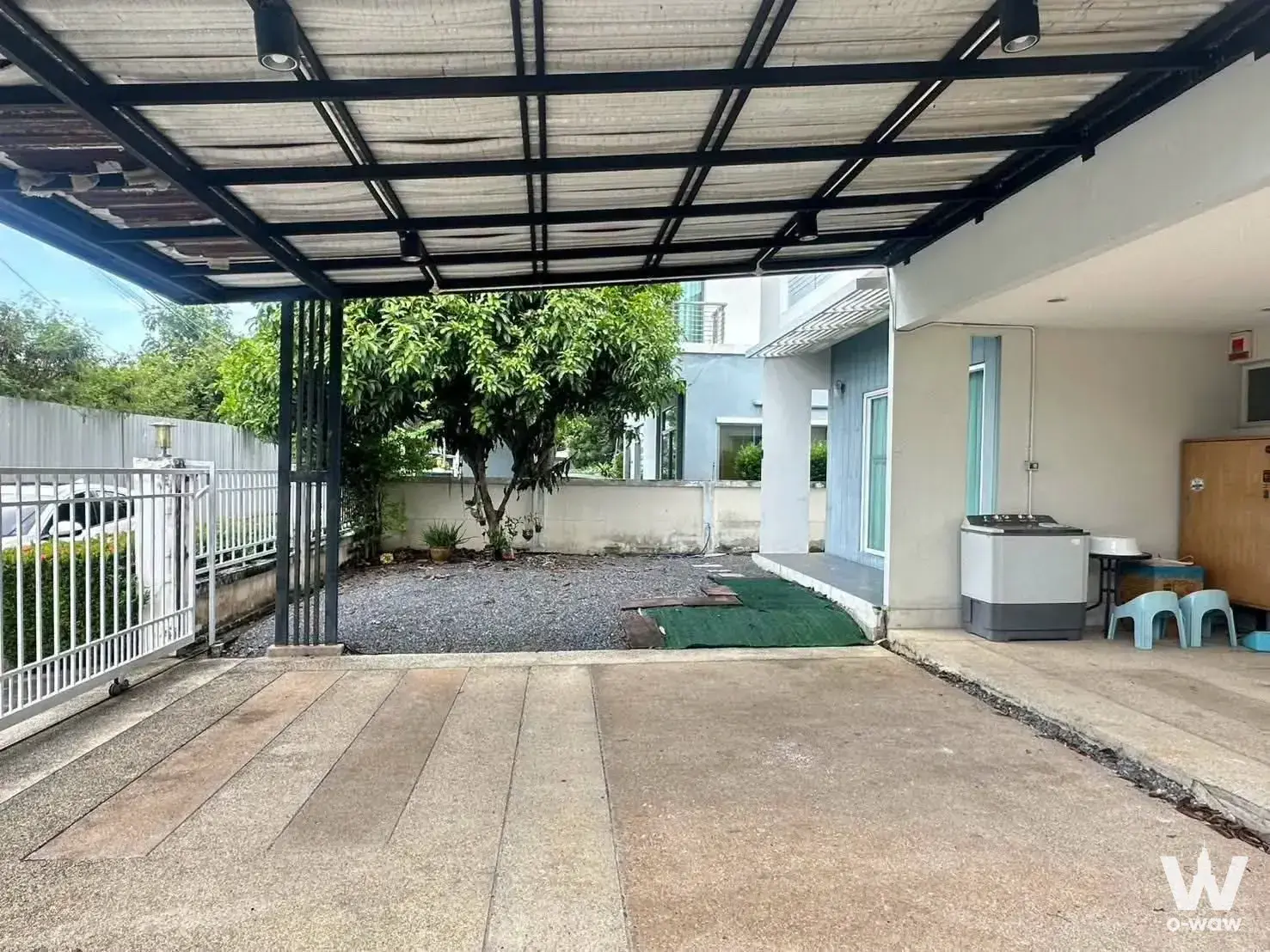 Covered carport at Perfect Place 2 with a steel roof, sliding gate, and outdoor utility sink