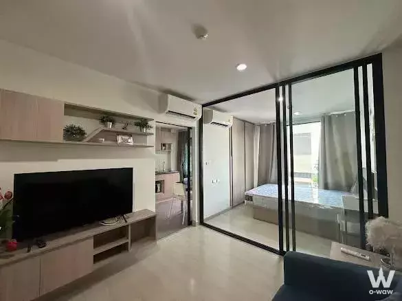 Bright 1-bed condo for rent at The Niche Mono Sukhumvit 50 with white tiles, wood accents, and sliding glass doors