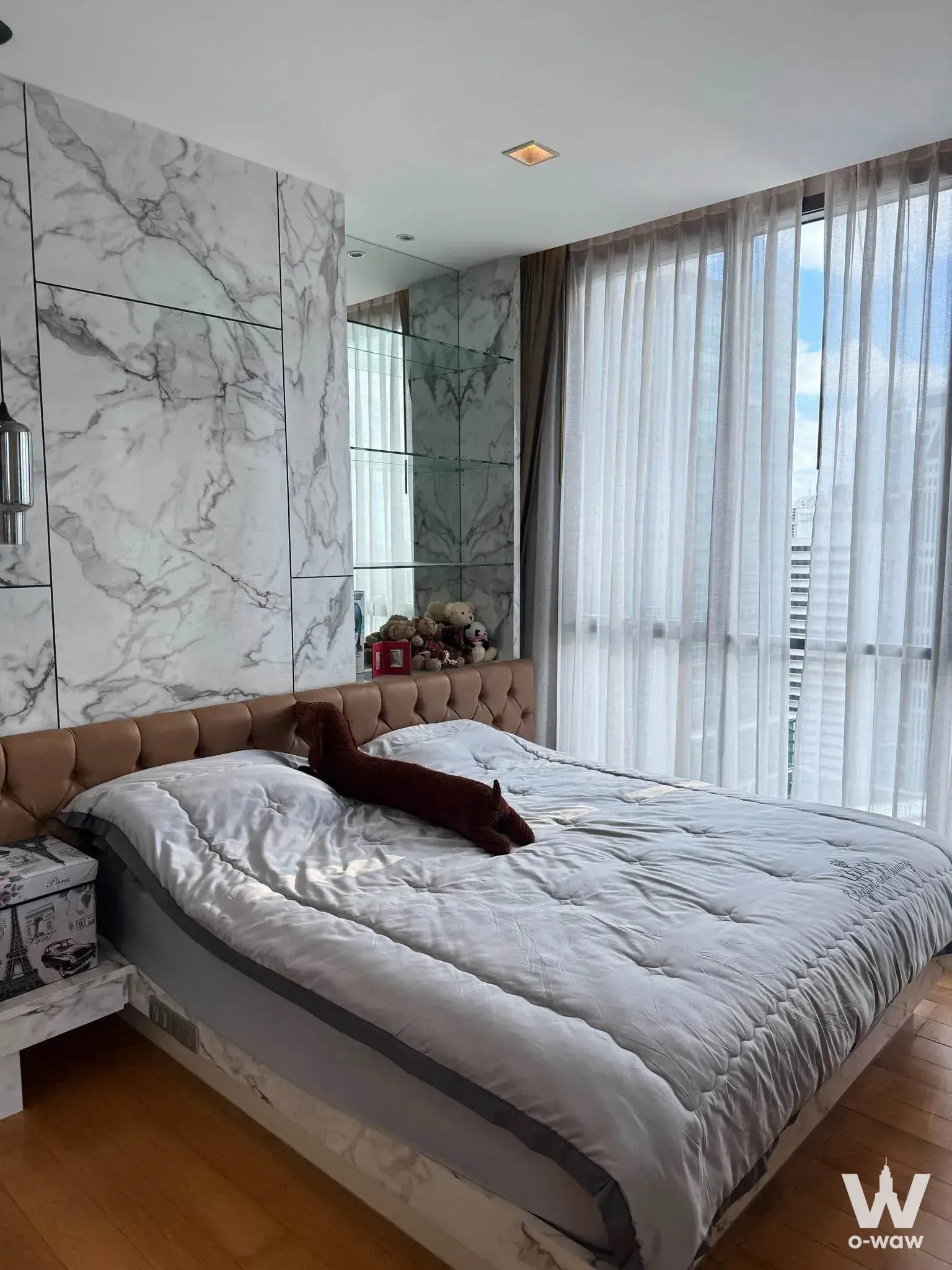 Queen bed in Hyde Sukhumvit 13 rental bedroom with marble accent wall and city views