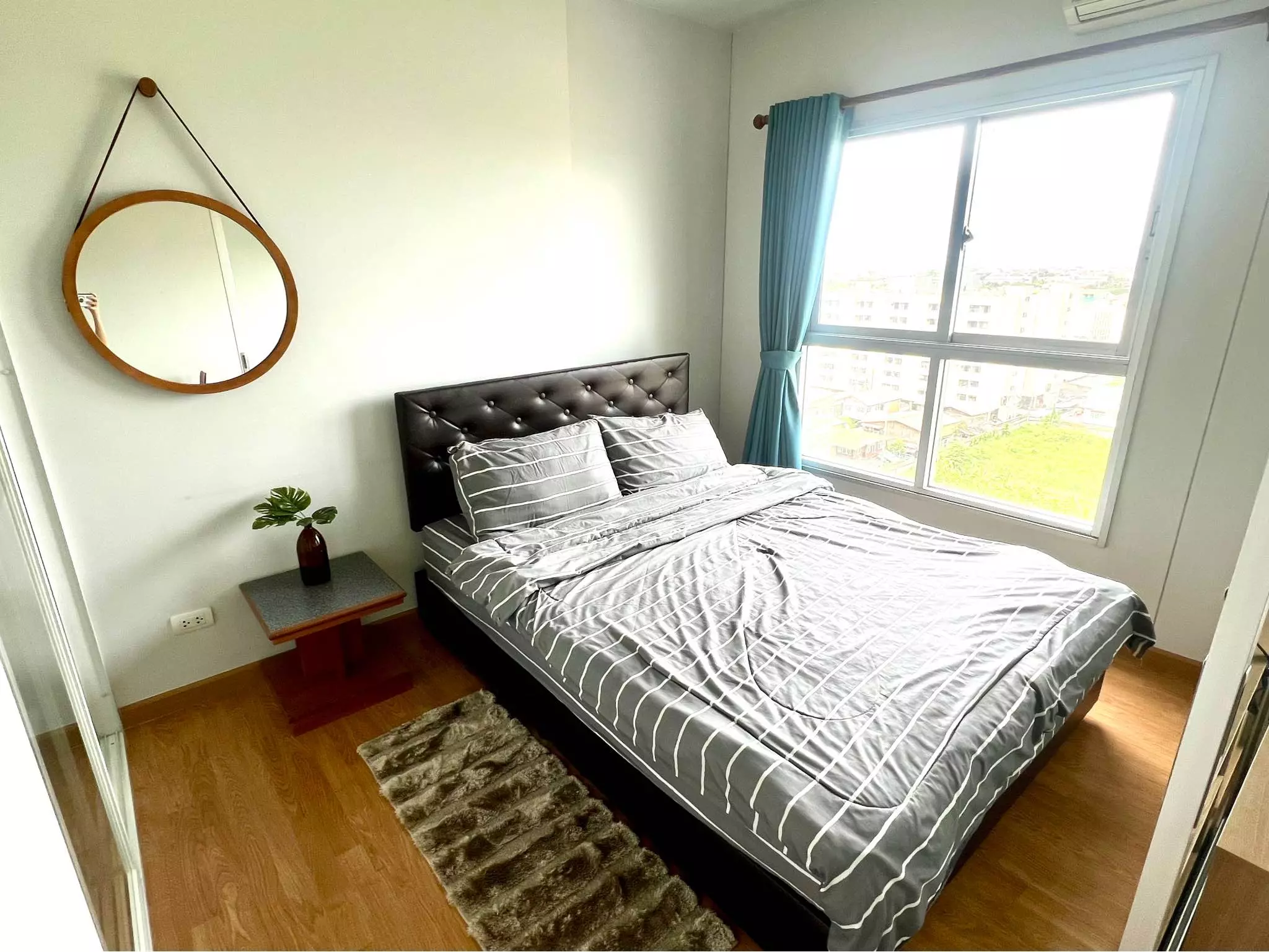 Bright bedroom in 1-bed condo for rent at The Parkland Phetkasem with black tufted headboard and teal curtains