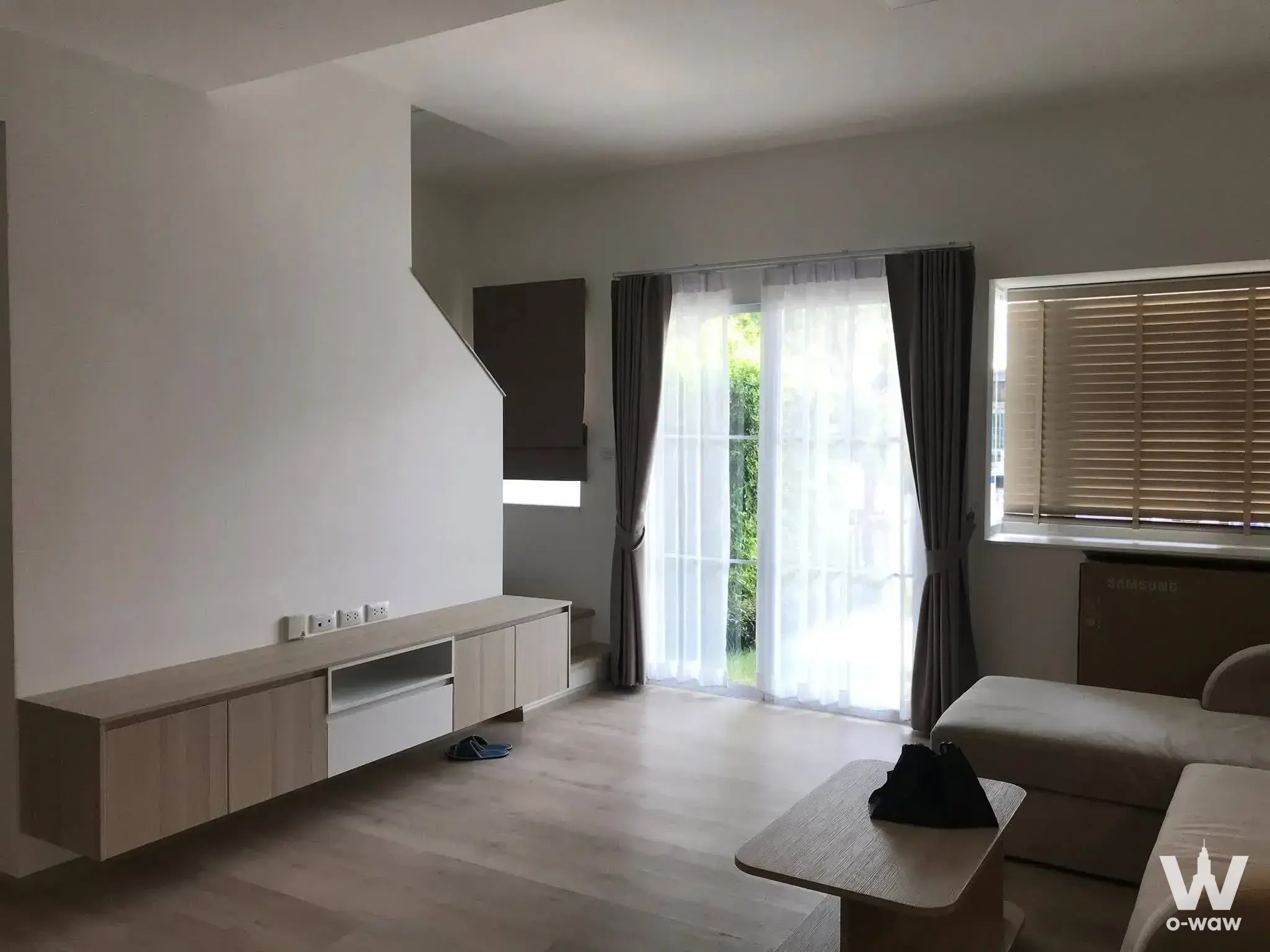 Modern living room in 2-bed house for rent at Villaggio 2 Srinakarin-Bangna with oak console and floor-to-ceiling windows