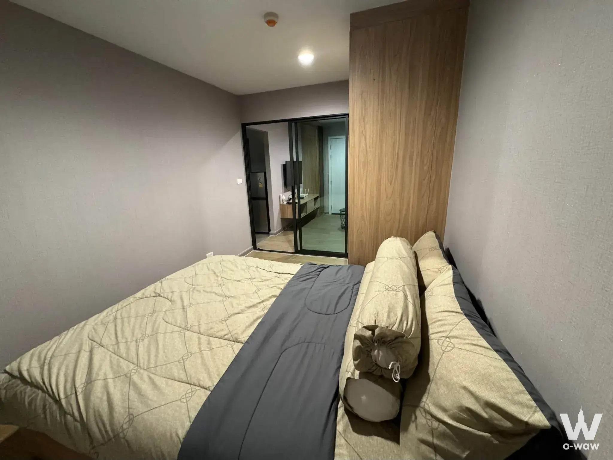 Modern bedroom with beige duvet and bathroom access in Polis Condo rental unit