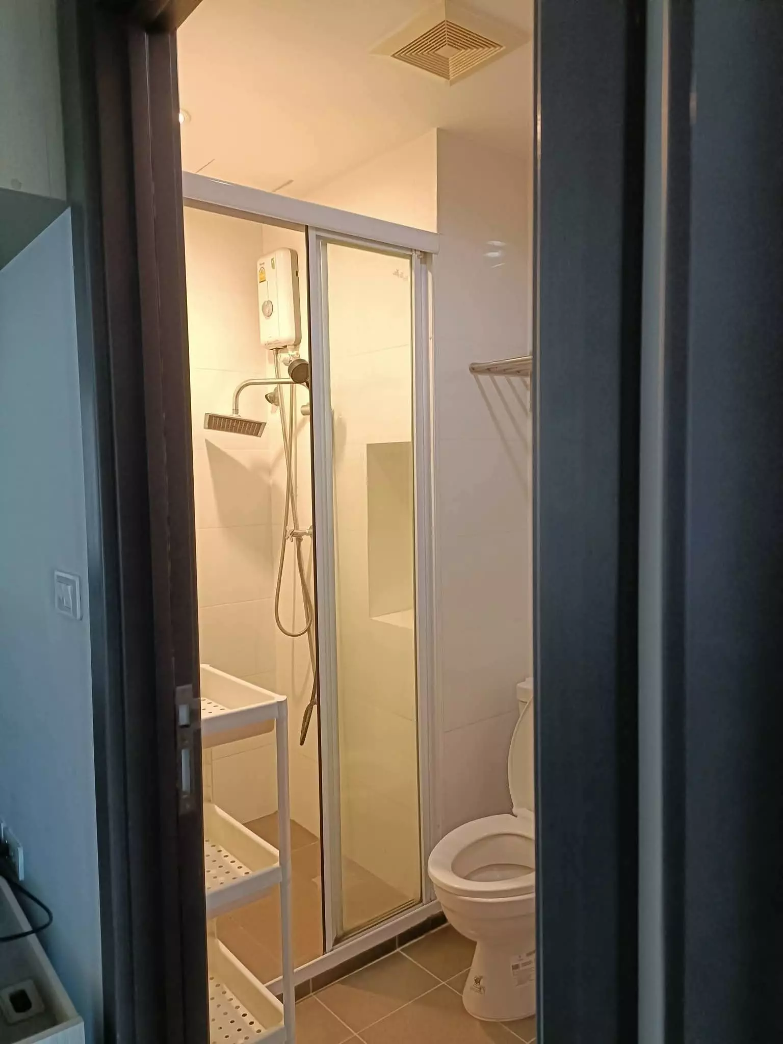 Modern bathroom in 1-bed condo for rent at THE BASE Park West Sukhumvit 77 featuring rainfall shower and beige tiles