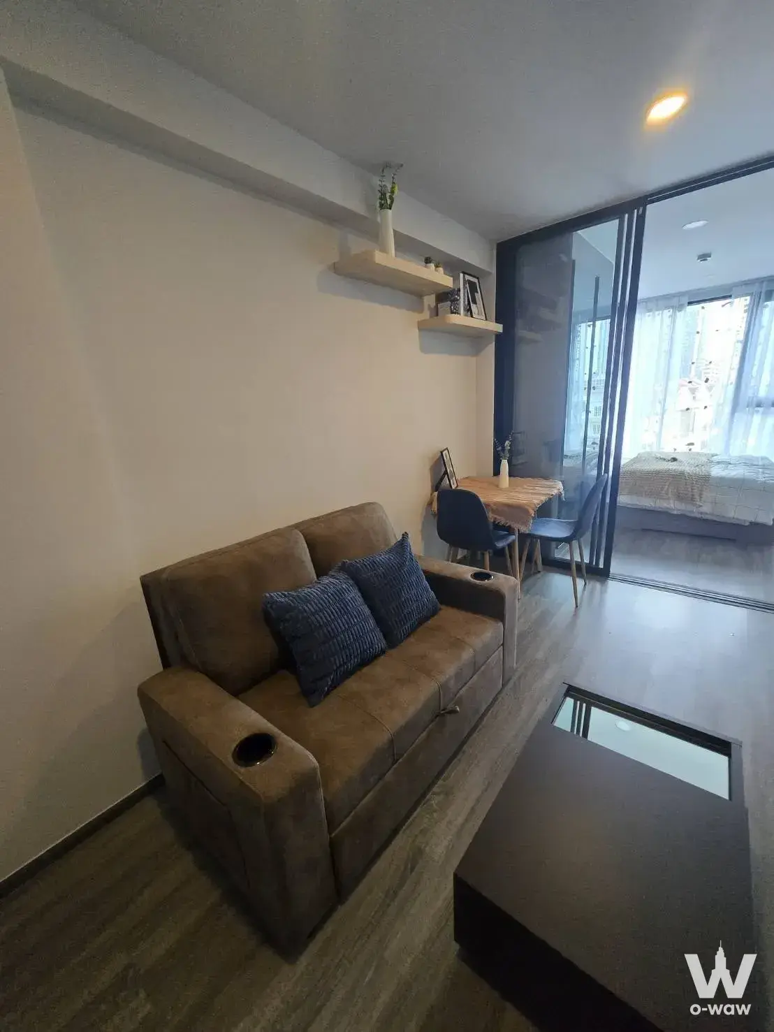 Cozy living space in The Origin Ladprao 15 with brown suede sofa and corner dining nook